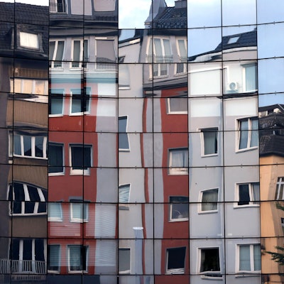 Häuser spiegeln sich in einer Fassade in der Kölner Innenstadt. In Deutschland ist der Mietspiegel eine der gesetzlich vorgesehenen Möglichkeiten für die Ermittlung der ortsüblichen Vergleichsmiete. Themenbild, Symbolbild Köln, 20.06.2025 NRW Deutschland *** Houses are reflected in a façade in the center of Cologne In Germany, the rent index is one of the statutory options for determining the local comparative rent Themed image, symbolic image Cologne, 20 06 2025 NRW Germany Copyright: xChristophxHardtx