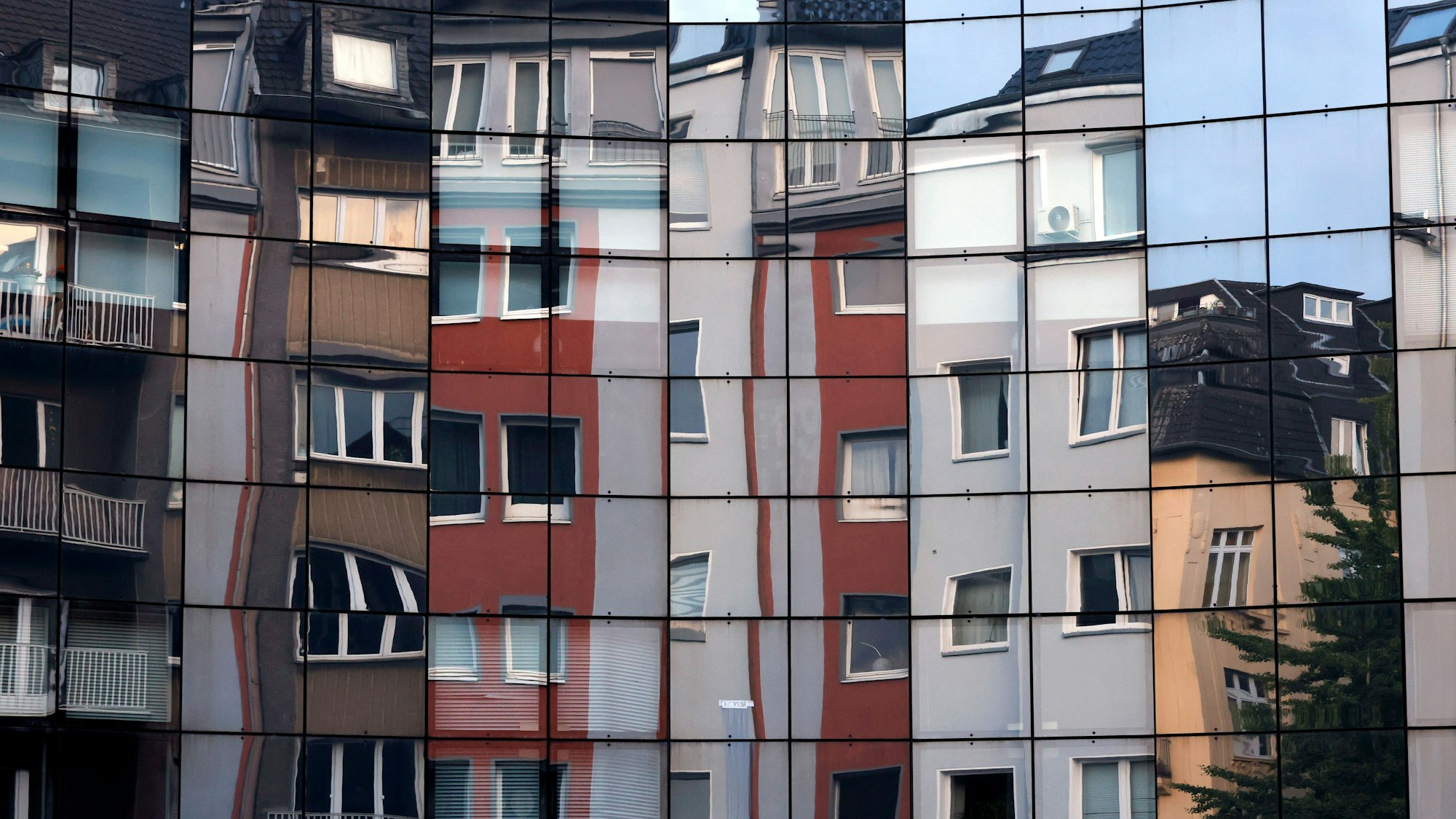 Häuser spiegeln sich in einer Fassade in der Kölner Innenstadt. In Deutschland ist der Mietspiegel eine der gesetzlich vorgesehenen Möglichkeiten für die Ermittlung der ortsüblichen Vergleichsmiete. Themenbild, Symbolbild Köln, 20.06.2025 NRW Deutschland *** Houses are reflected in a façade in the center of Cologne In Germany, the rent index is one of the statutory options for determining the local comparative rent Themed image, symbolic image Cologne, 20 06 2025 NRW Germany Copyright: xChristophxHardtx