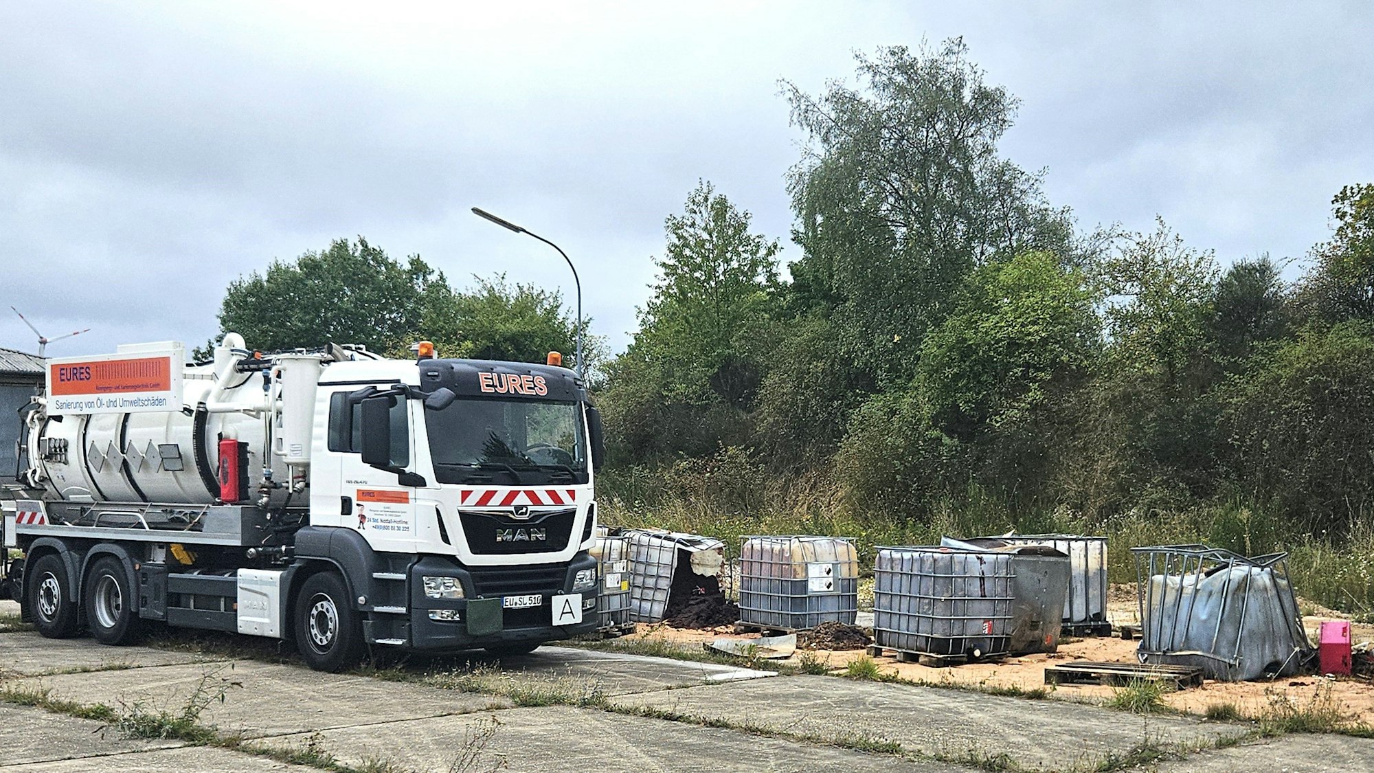 Zu sehen ist ein großer Lkw der Firma und einige der Container.