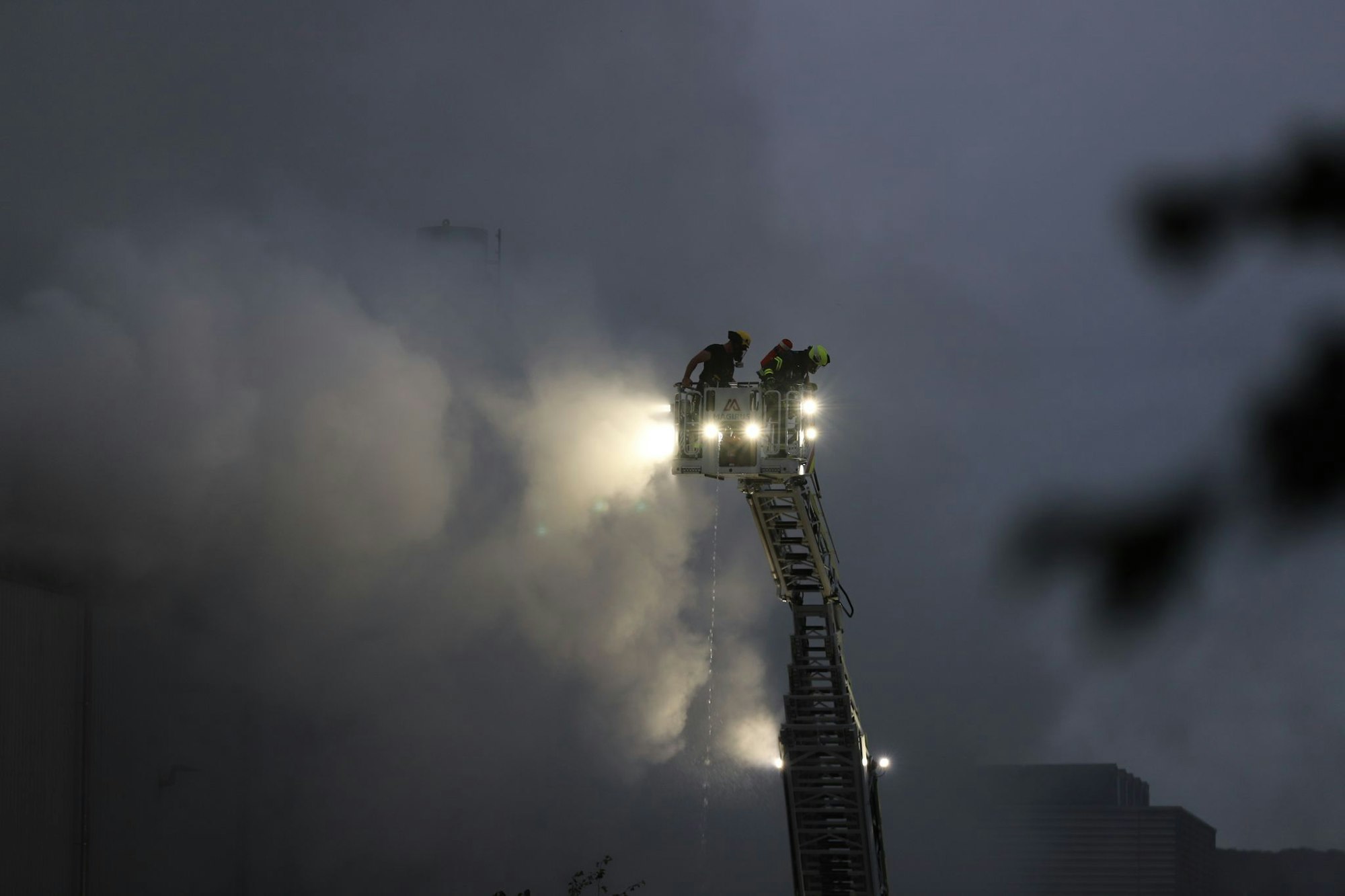 Über eine Drehleiter kämpfen Feuerwehrleute an der Sperrmüll-Halle gegen den Brand.