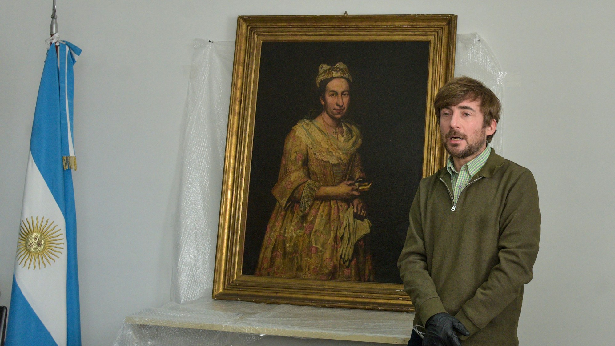 Ein Lehrer präsentiert in Mar del Plata das Gemälde „Portrait of a Lady“ von Giuseppe Ghislandi, das als NS-Raubkunst gilt und jahrzehntelang verschollen war.