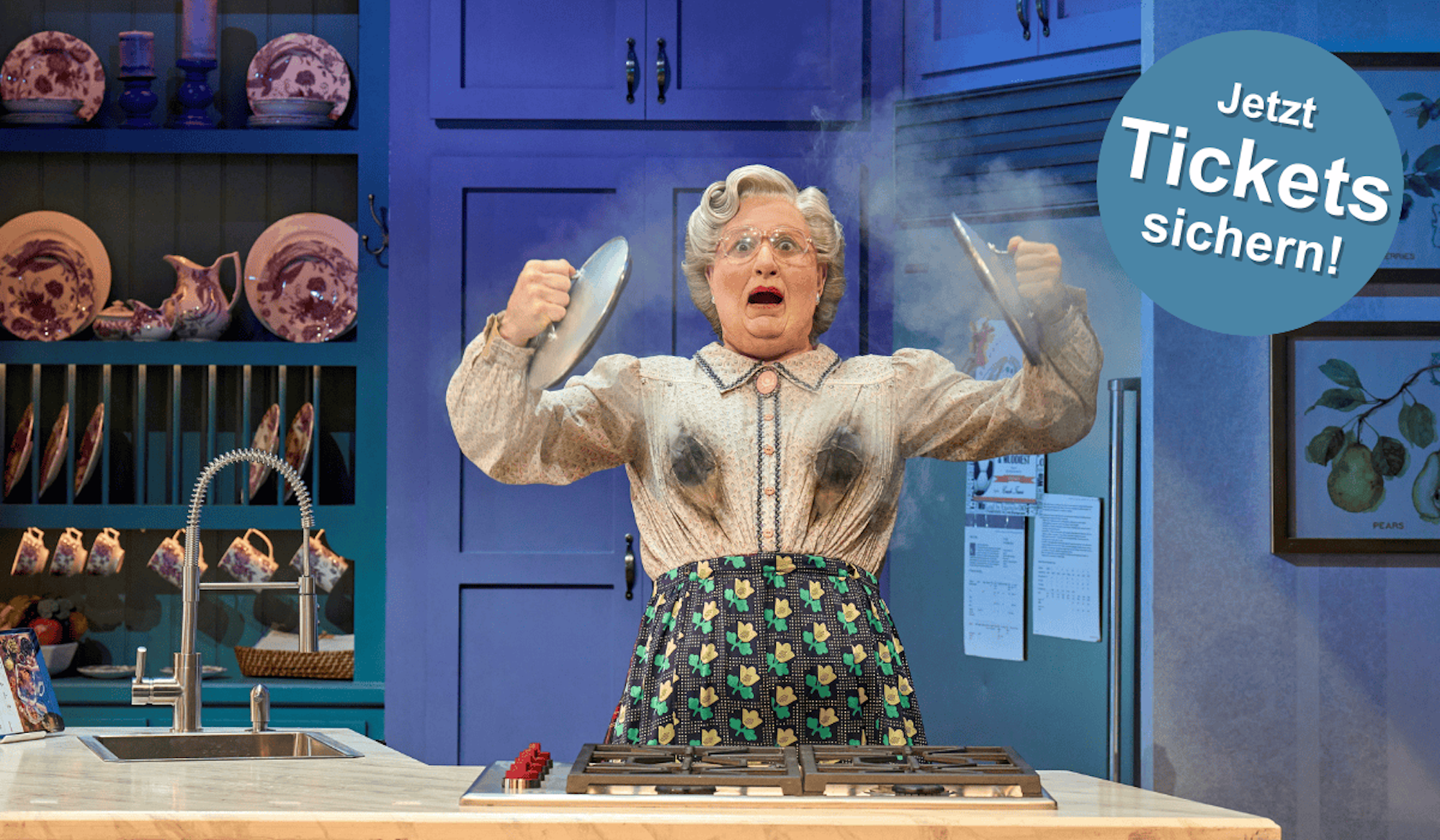 Bild aus dem Musical Mrs. Doubtfire. Mrs. Doubtfire steht in einer Küche mit Ruß auf der Kleidung und dampfenden Töpfen.