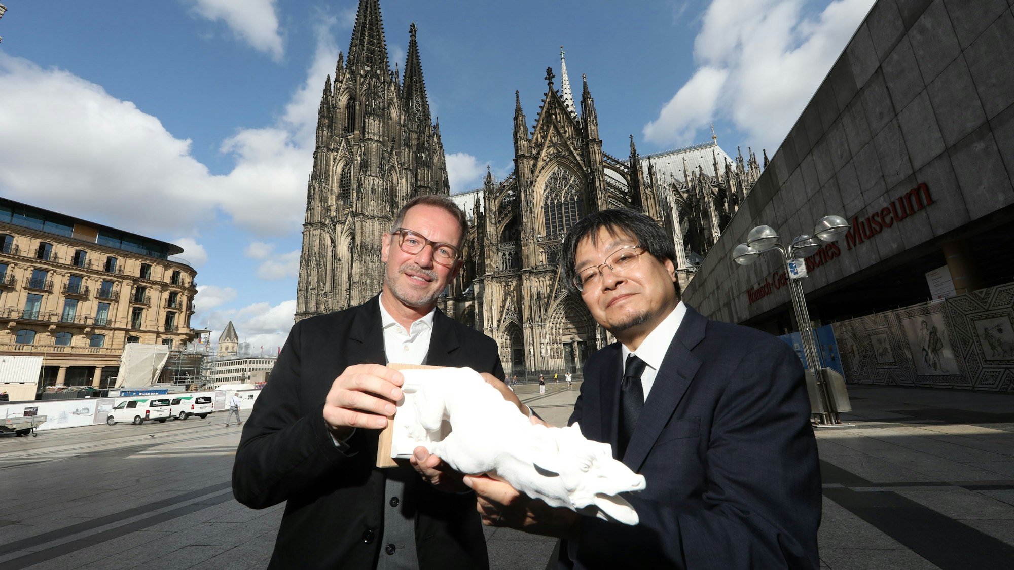04.09.2025, Köln: Dombaumeister Peter Füssenich überreicht als Dank eine Miniatur des Wasserspeiers an Ryusuke Toda. Offizielle Übergabe eines von der Kanagawa Universität gespendeten Wasserspeiers für den Kölner Dom. Die Spende kam zu Stande, nachdem im Jahr 2016 japanische Studentinnen im Bereich der Domturmbesteigung ein Graffiti hinterlassen hatten. Ihre Universität schickte mit der Bitte um Entschuldigung eine Delegation nach Deutschland. Foto: Arton Krasniqi