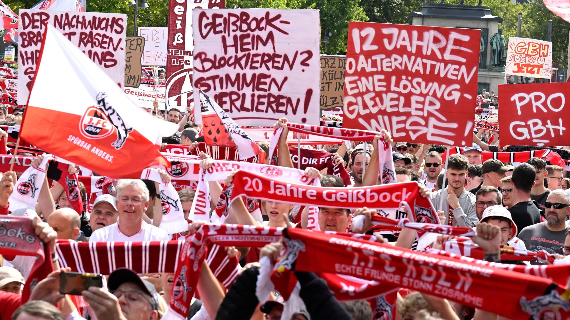 Fans des Fußball-Bundesligisten 1. FC Köln demonstrieren auf dem Heumarkt für die Erweiterung des Geissbockheims. Sie tragen Plakate, FC-Fahnen und FC-Schals.