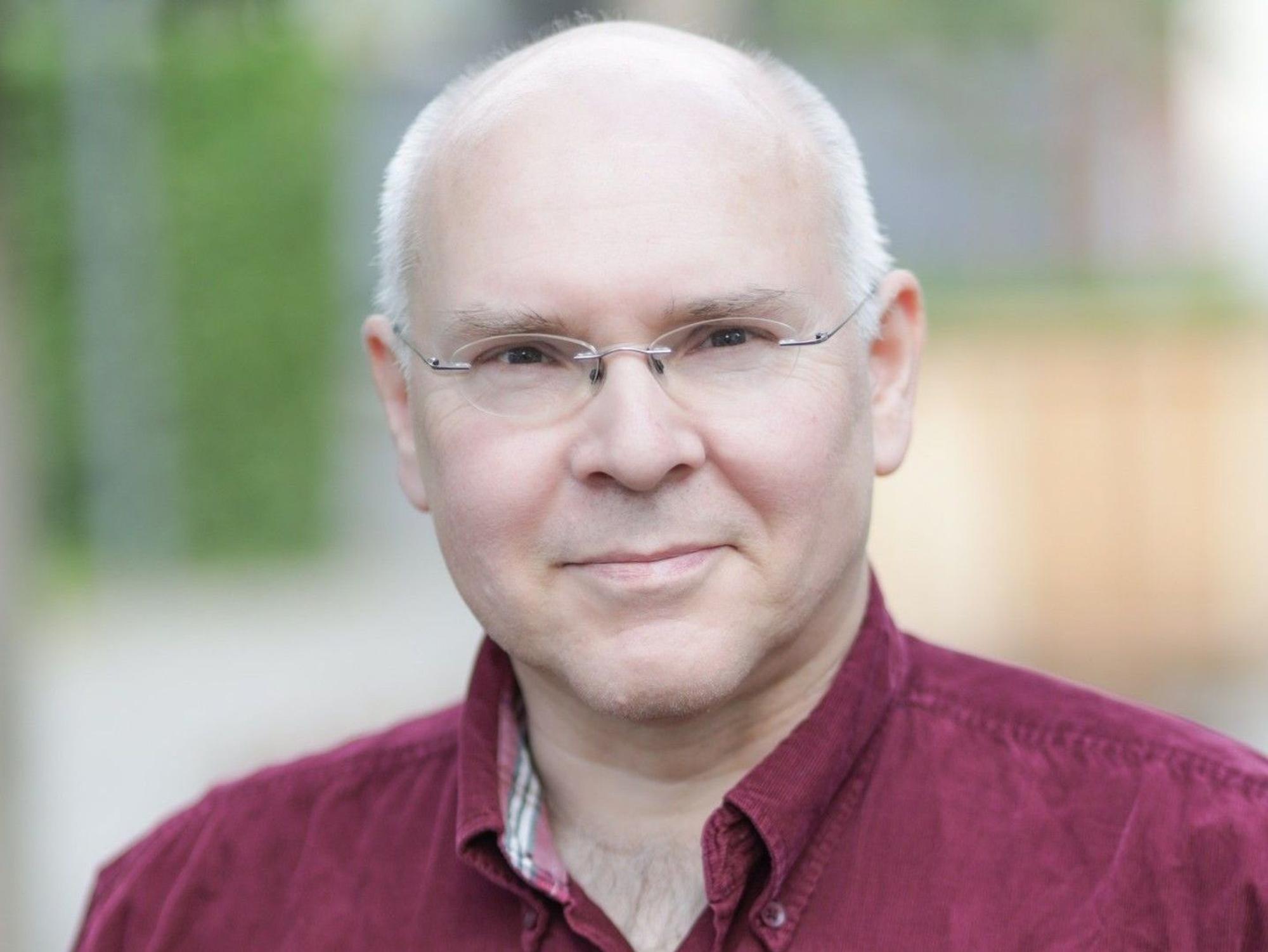 Hartmut Schielke steht im Hemd vor einem unscharf gestellten Hintergrund.