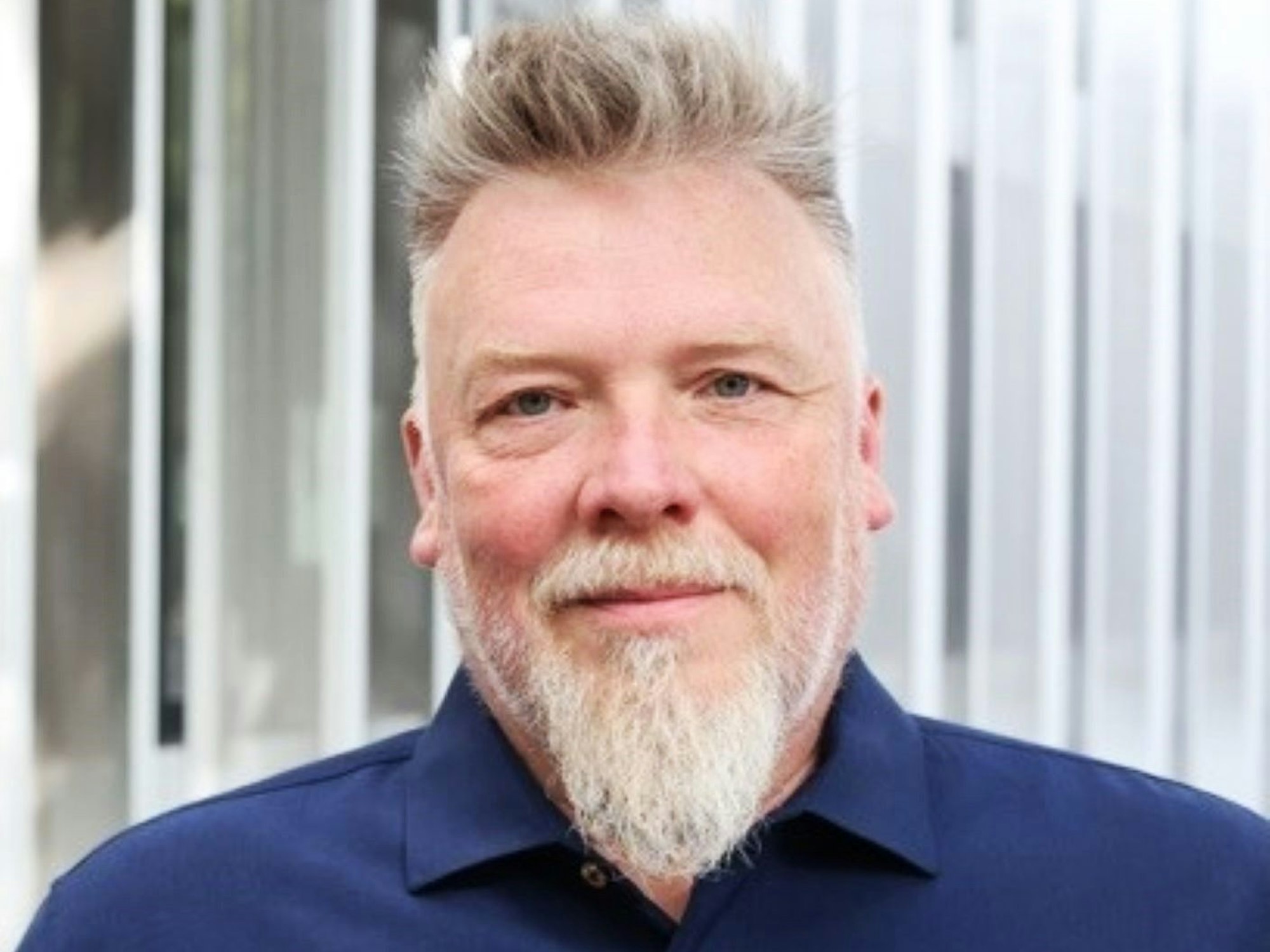 Porträtbild von Michael Sauer, der ein dunkelblaues Hemd trägt.