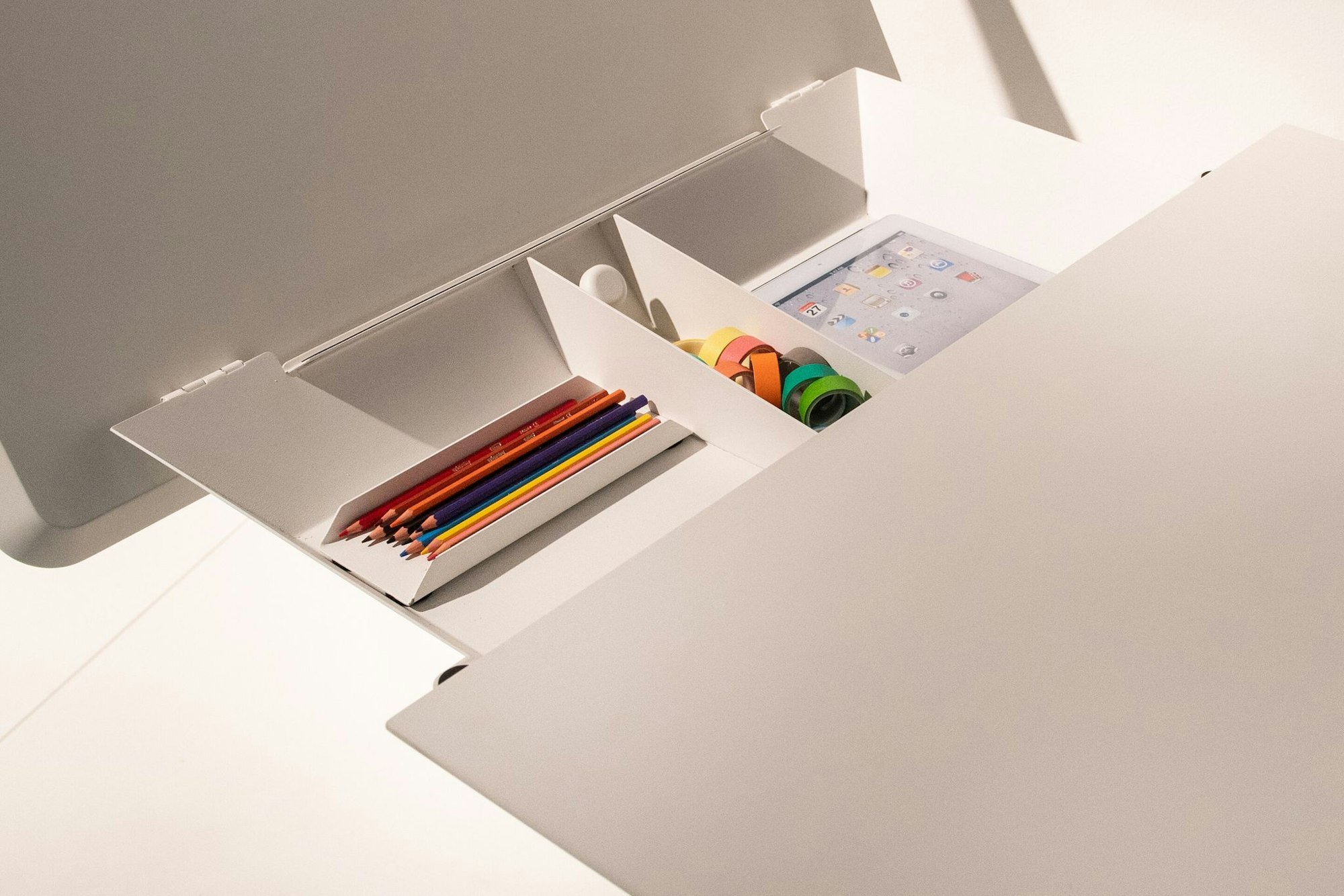 Auch kleine Schreibtische bieten Stauraum unter einer hochklappbaren Platte, wie dieses Modell von Müller Small Living.