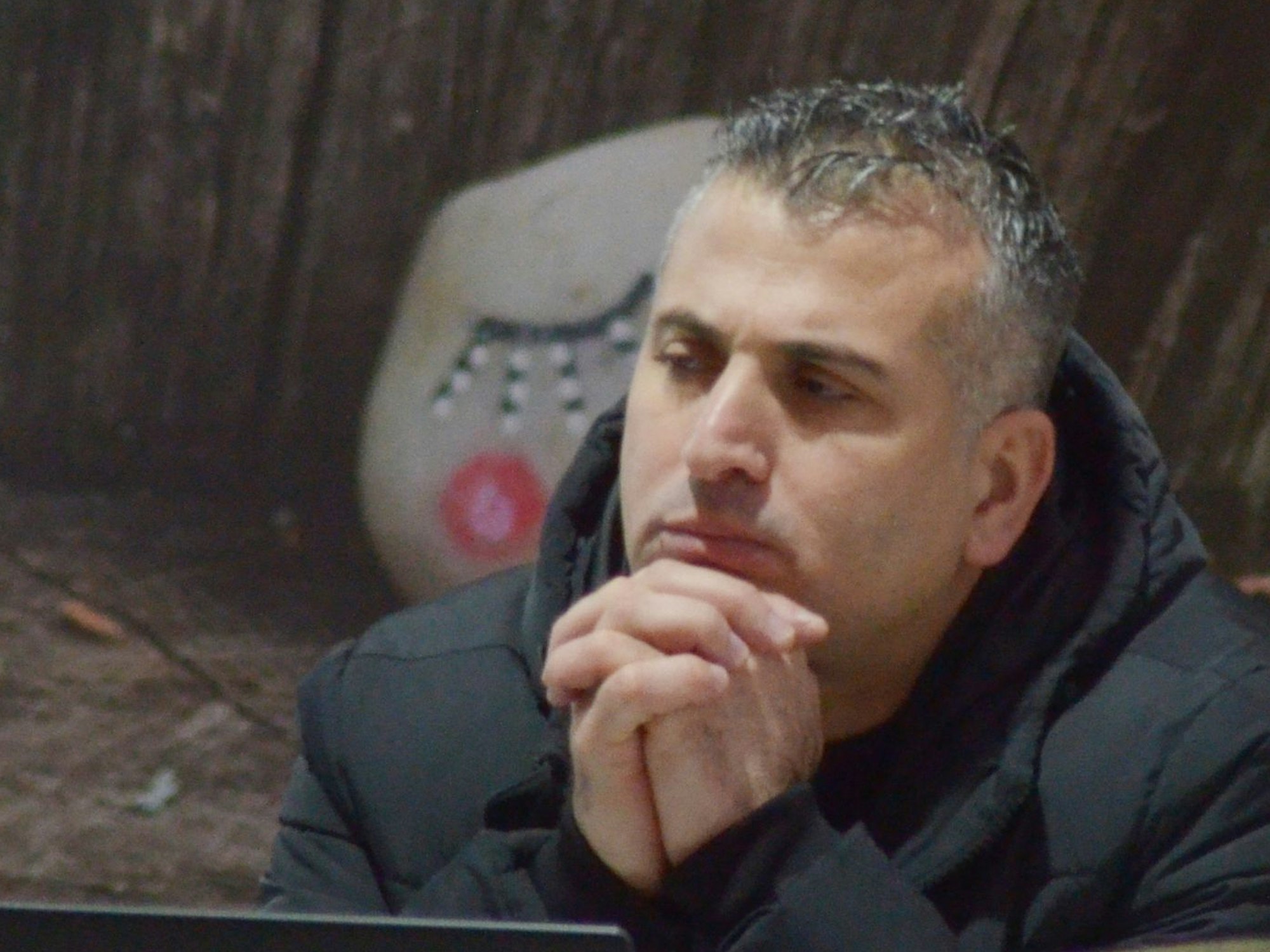 Cuma Kaya (FE) hat bei einer Sitzung des Euskirchener Stadtrats die Hände zusammengefaltet.