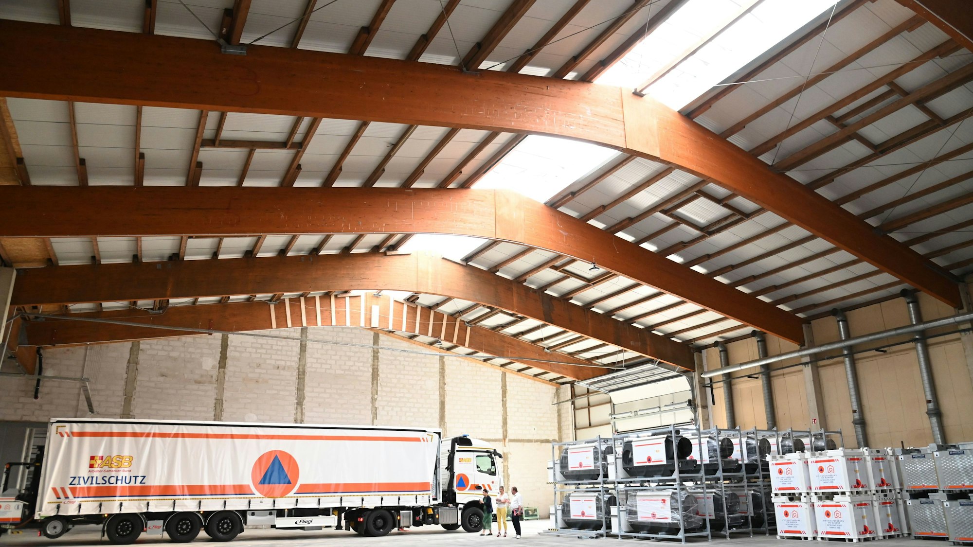 In der Lagerhalle ist ein LKW zu sehen, davor Tanks in weiß mit orangener Aufschrift. Foto: Alexander Schwaiger