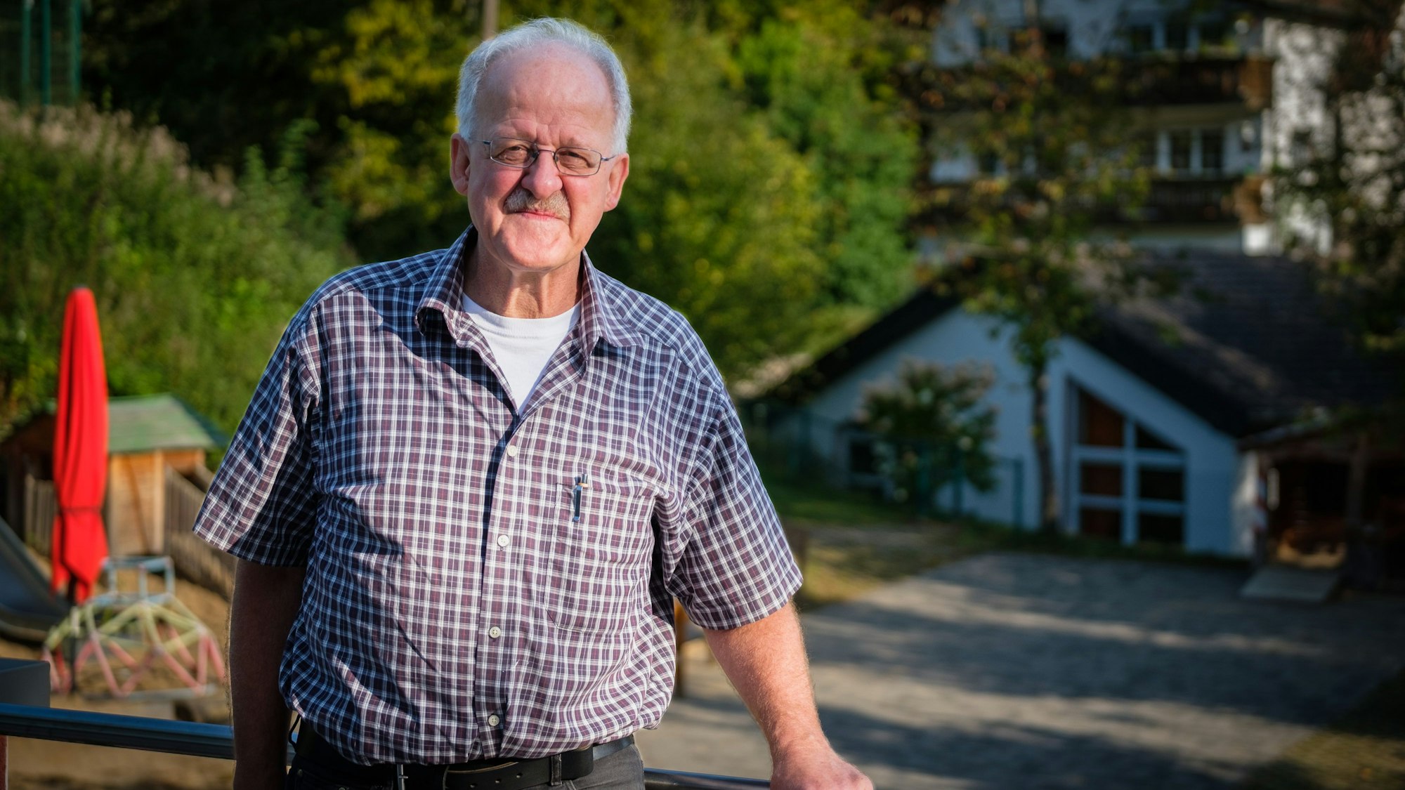Ein Mann im Karohemd lächelt in die Kamera.