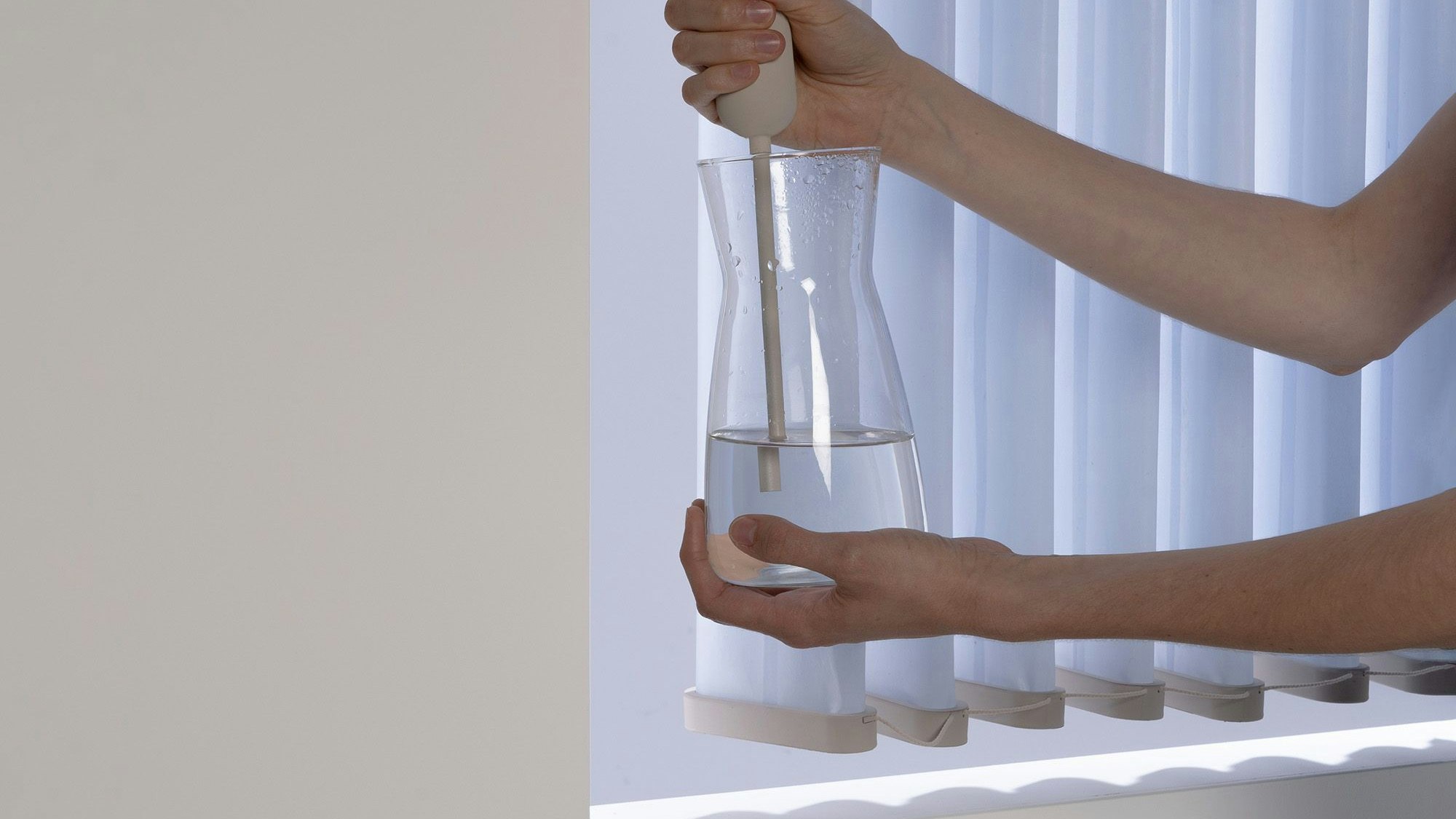 Eine Frau pumpt Wasser in einen Lamellenvorhang.