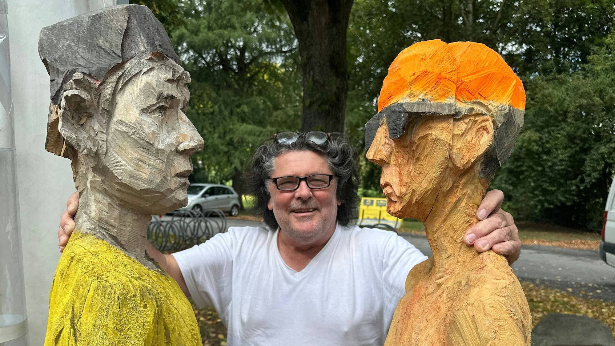 Vorbereitung der Ausstellung Skulpturzeit '25 auf Burg Wissem, Clemens Heinl an zwei seiner Holzskulpturen.