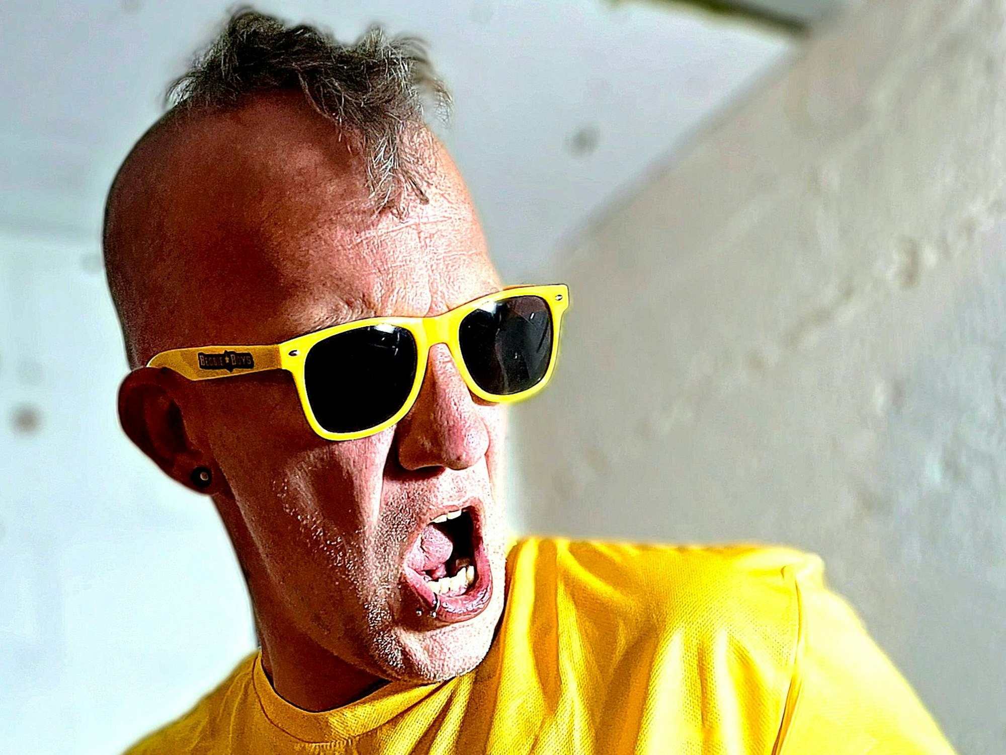 Martin Oertel trägt ein für die Politik untypisch knalliges Outfit, inskluive gelbumrandeter Sonnenbrille.