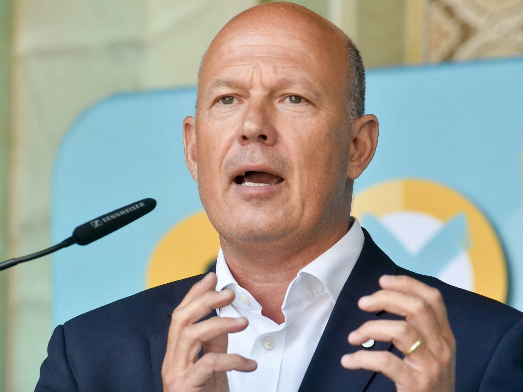 Auf dem Bild ist ein Portrait eines Mannes im Anzug zu sehen.