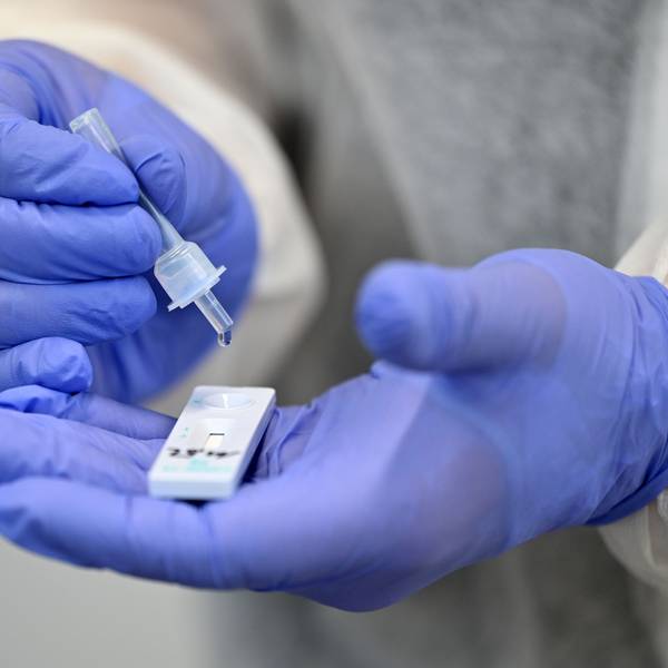 Ein Helfer verarbeitet eine Probe für einen Corona-Schnelltest.