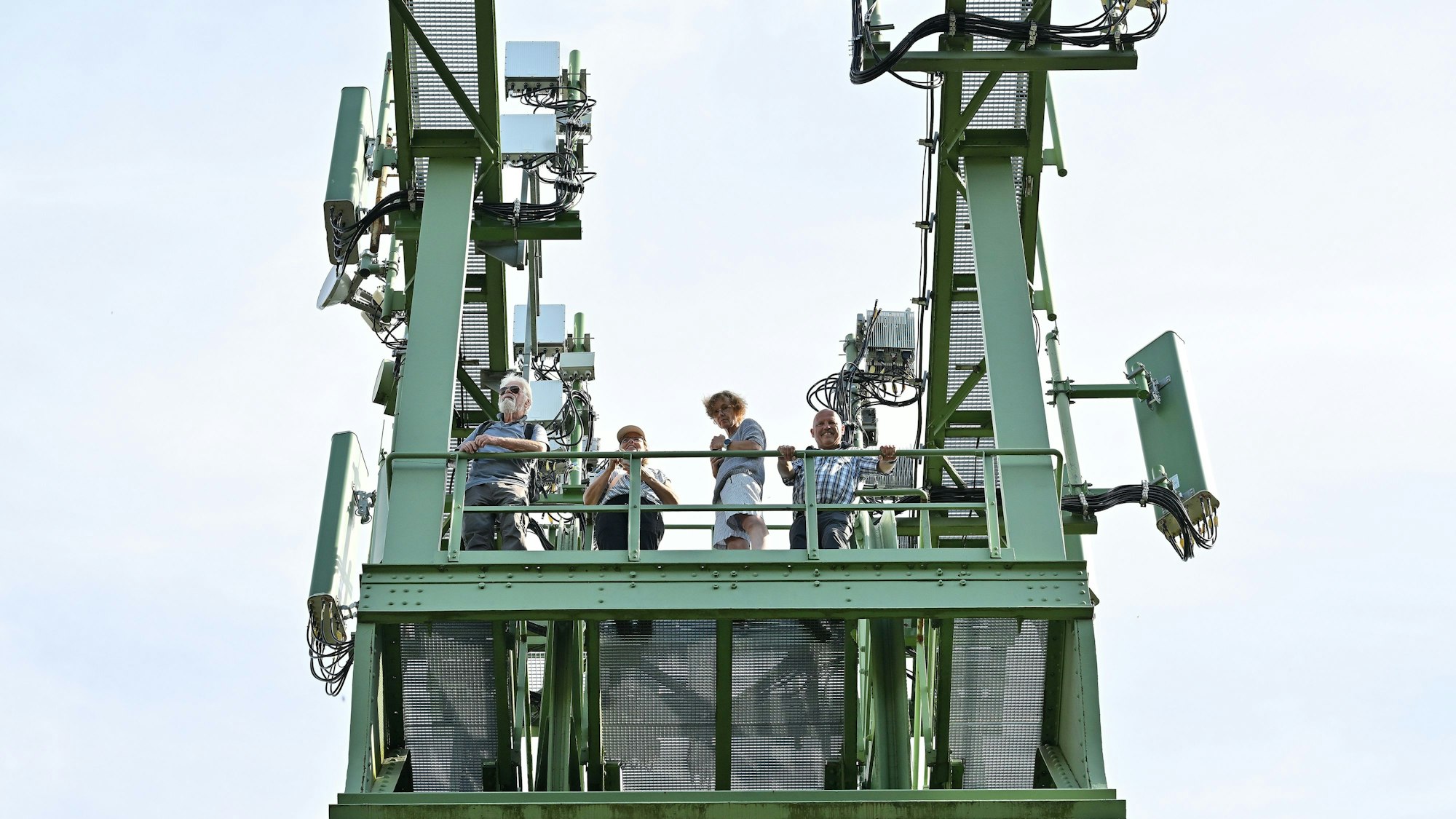 Einige Wanderer stehen oben auf einem Förderturm.