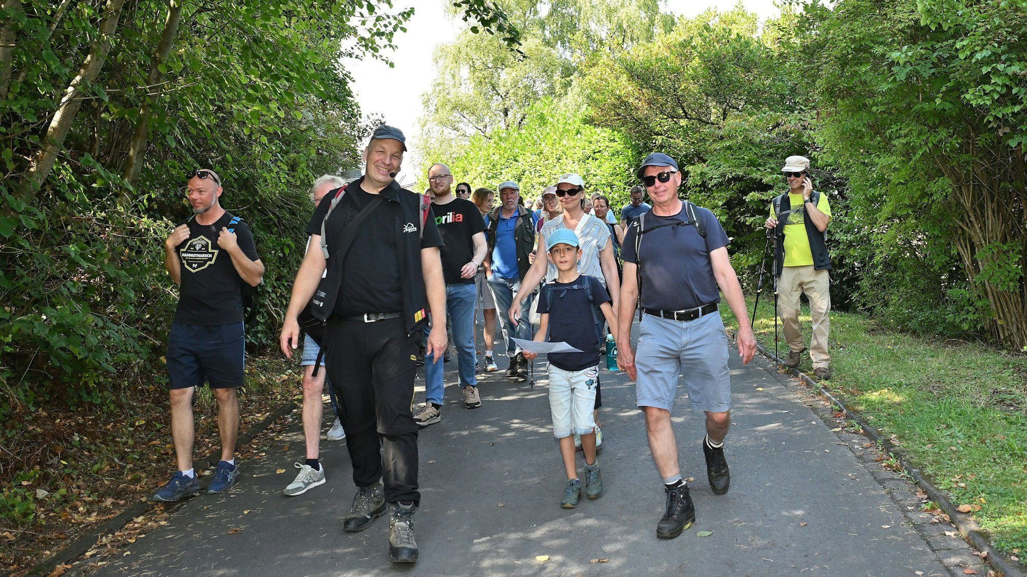 Eine Gruppe von Wanderern läuft einen Weg entlang, darunter Wanderführer Guido Wagner.