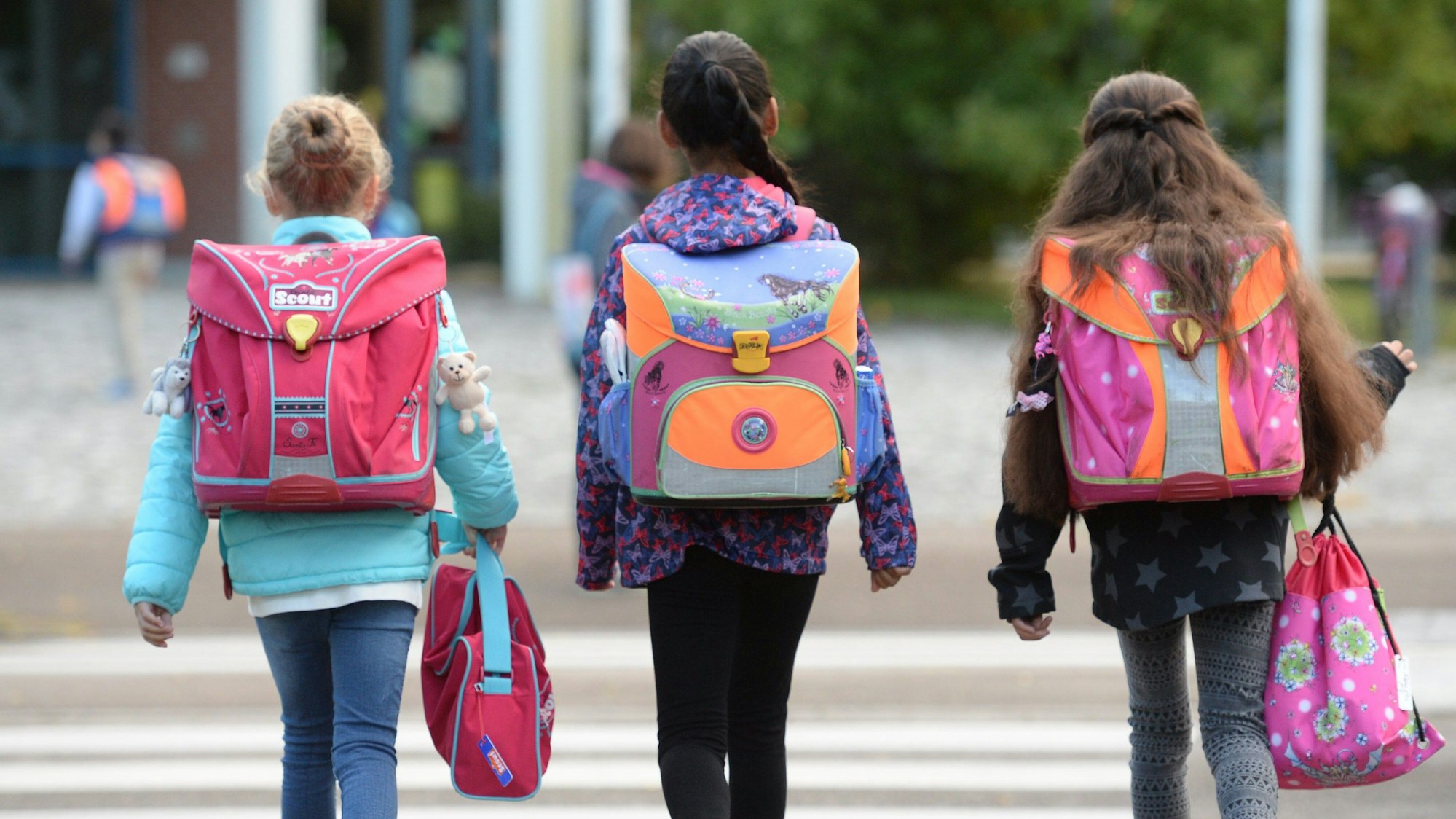 ARCHIV - Drei Schülerinnen laufen am 14.09.2015 in Freiburg (Baden-Württemberg) mit ihren Schulranzen zur Schule. (zu dpa «NVV-Aufsichtsrat berät über Schülerticket» vom 15.03.2017) Foto: Patrick Seeger/dpa +++ dpa-Bildfunk +++