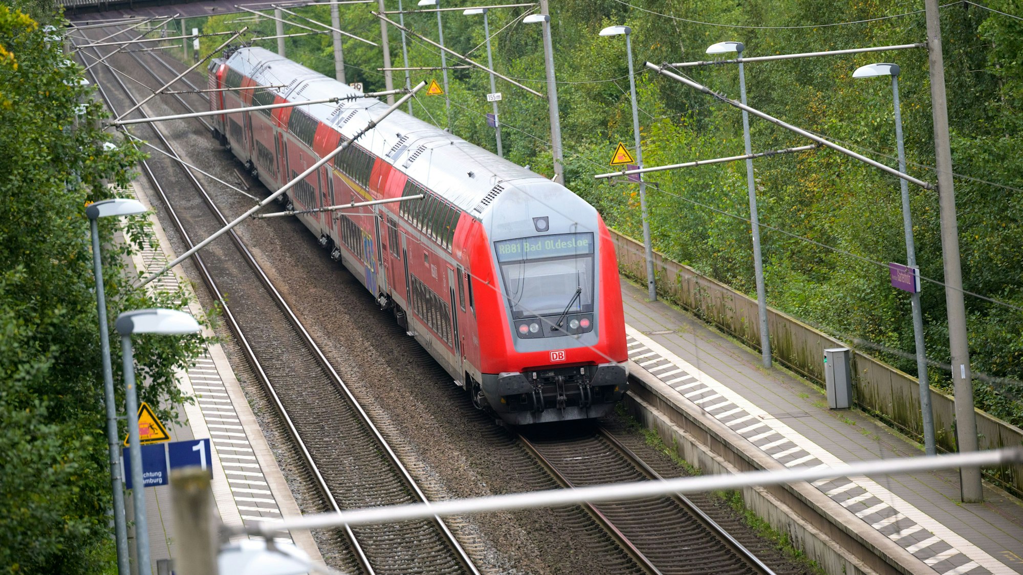 Ein doppelstöckiger Regionalzug der Deutschen Bahn (DB) fährt durch einen Bahnhof.