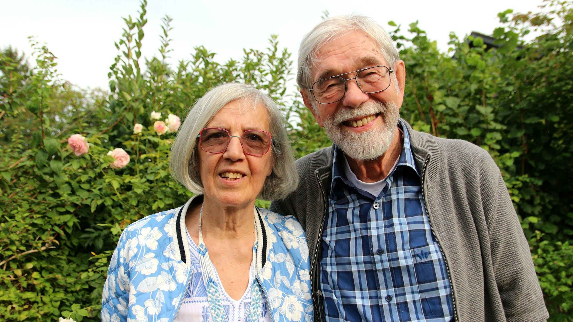 Das Bild zeigt das ältere Paar draußen im Grünen.