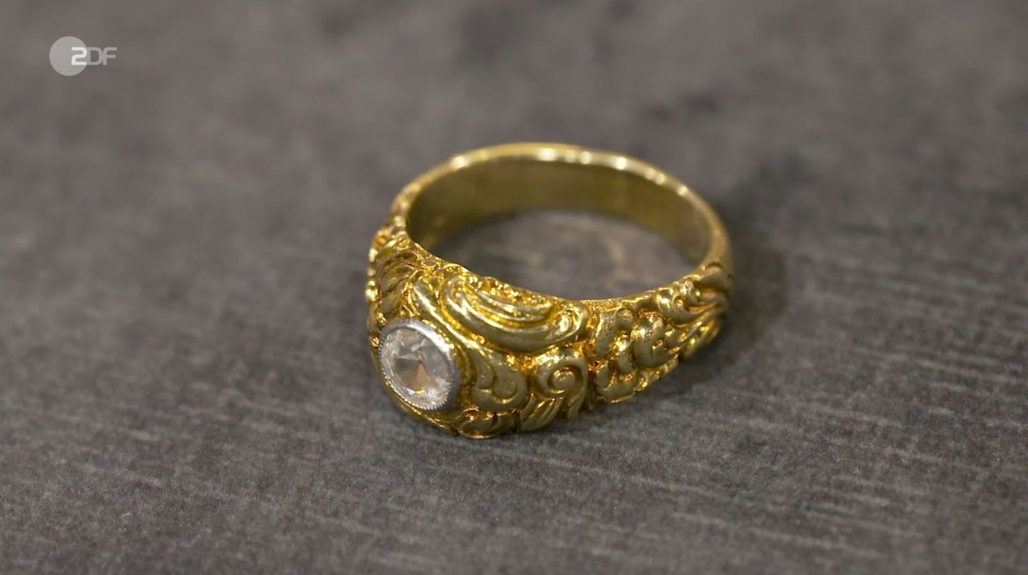 Heide Rezepa-Zabel datierte einen Bandring aus 585er Gold mit einem Brillant (0,7 Karat) im Altschliff zwischen 1890 und den 1920er Jahren. Der Wunschpreis lag bei 500 Euro. Die Expertin schätzte 1.200 bis 1.400 Euro und Händlerin Elke Velten zahlte letztlich 1.300 Euro für den „besonderen Schmuck im Top-Zustand“. (Bild: ZDF)