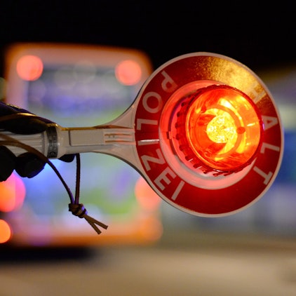 ILLUSTRATION - Beamte der Mobilen Kontroll- und Überwachungseinheit (MKÜ) der Bundespolizei kontrollieren am 14.11.2015 in Kehl (Baden-Württemberg) an der Europabrücke in der Nacht Fahrzeuge. Einer Beamter hält dabei seine Haltekelle in die Höhe.