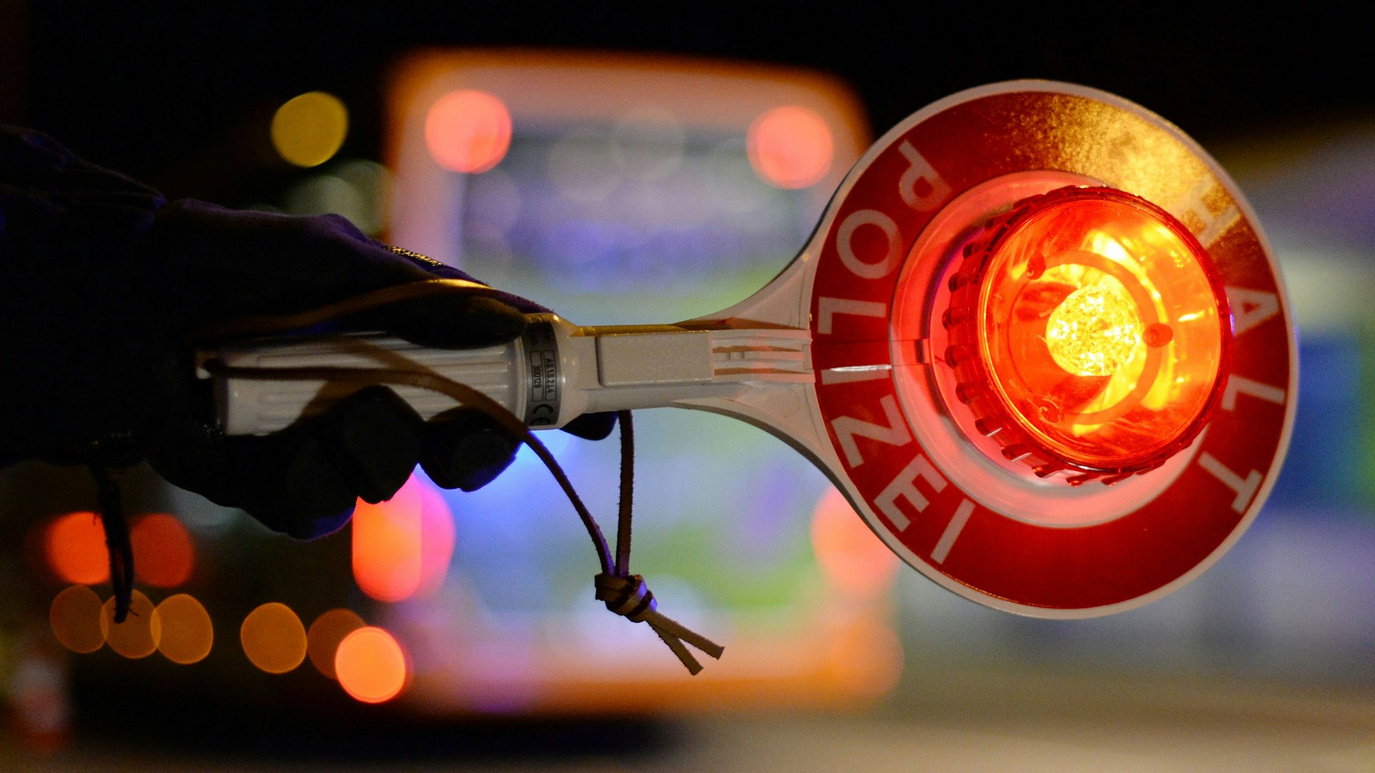 ILLUSTRATION - Beamte der Mobilen Kontroll- und Überwachungseinheit (MKÜ) der Bundespolizei kontrollieren am 14.11.2015 in Kehl (Baden-Württemberg) an der Europabrücke in der Nacht Fahrzeuge. Einer Beamter hält dabei seine Haltekelle in die Höhe.