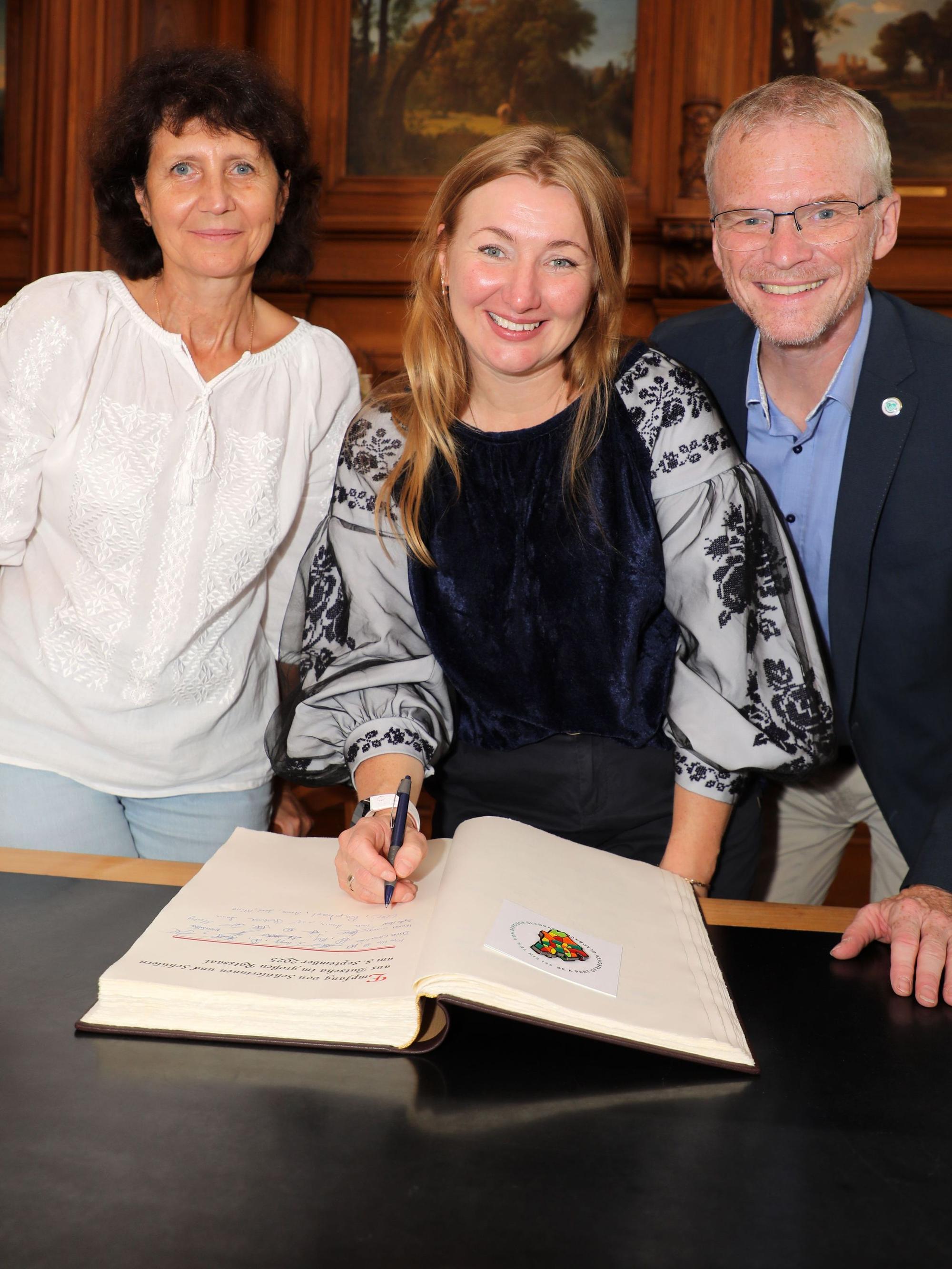 Bürgermeister Frank Stein mit den ukrainischen Lehrerinnen Tanja Rybakova und Iryna Kukushkina beim Eintrag ins Goldene Buch der Stadt Bergisch Gladbach.