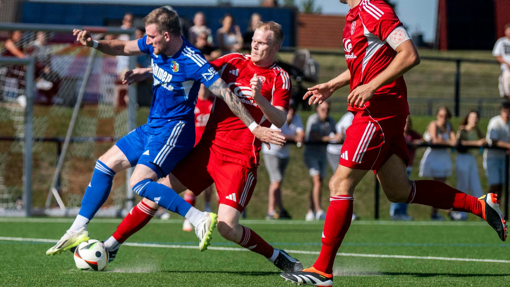 Ein Zülpicher Spieler spitzelt einem Gegenspieler von Teveren von hinten den Ball vom Fuß.