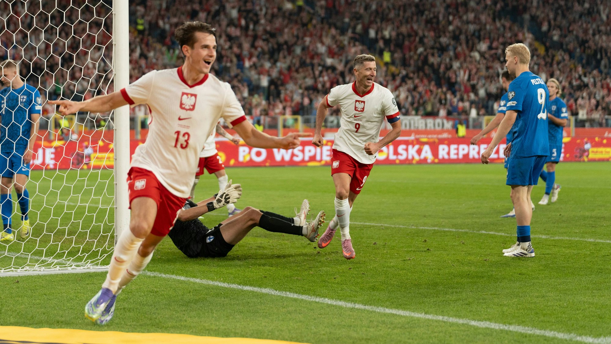 Jakub Kaminski dreht jubelnd ab, Vorbereiter Robert Lewandowski läuft zum Gratulieren herbei: Polen führt 2:0.