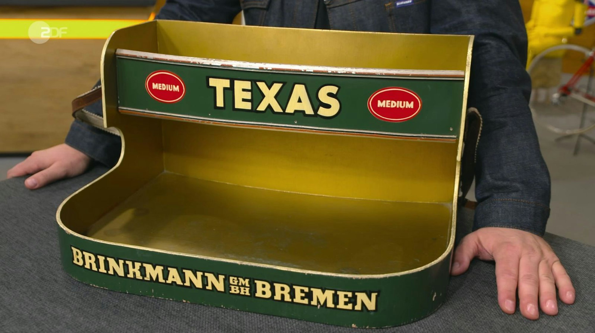 Der Bauchladen war tatsächlich ein Original aus den 1950er/60er Jahren und somit „absolut echt“. Der Verkaufsladen aus lackiertem Sperrholz stammte von der Firma Brinkmann AG - ein traditionsreiches Bremer Unternehmen der Tabakindustrie, das laut Expertise bereits 1878 gegründet wurde. (Bild: ZDF)