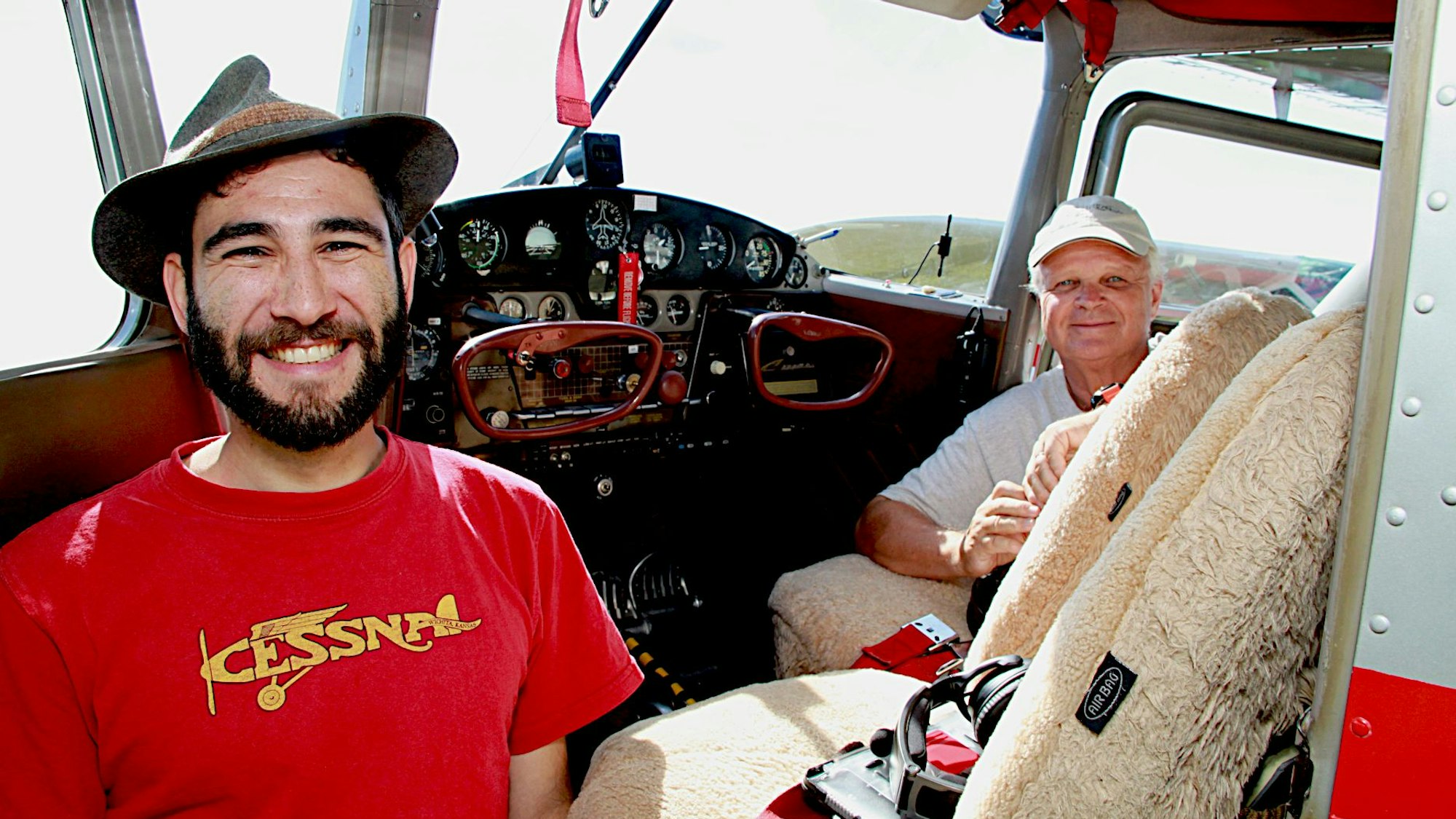 Zwei Männer stehen vor dem Cockpit ihres Cessna-Flugzeugs.