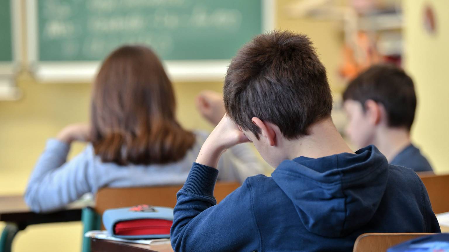 Schüler einer dritten Klasse einer Grundschule sitzen im Unterricht.
