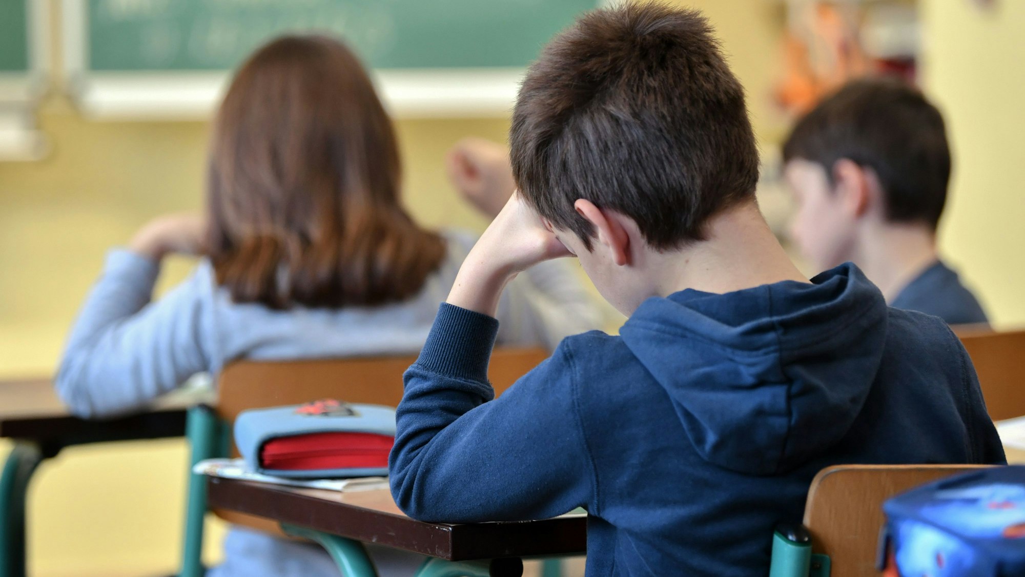 Schüler einer dritten Klasse einer Grundschule sitzen im Unterricht.