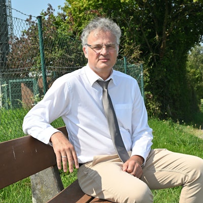 Sebastian Weirauch (AfD) sitzt auf einer Bank in einem Park.