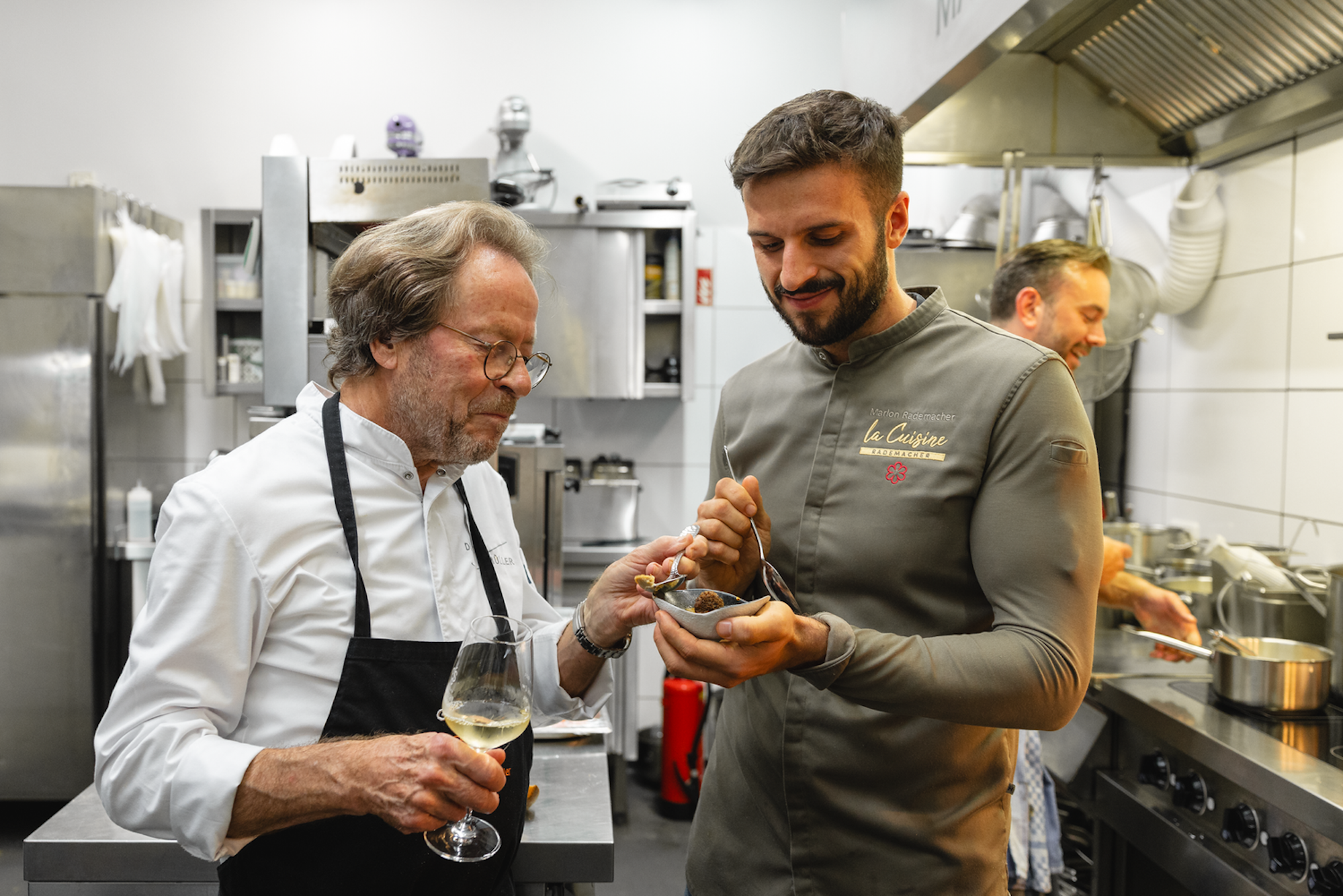 Dieter Müller (links) und Marlon Rademacher kosten Crème brûlée von der Gänseleber, einen Klassiker Müllers, beim Charity-Dinner für die Stiftung Kinderherz in Rademachers Restaurant „La Cuisine“ am 5.9.25