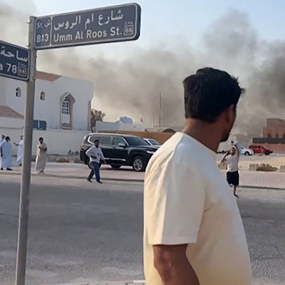 Ein Standbild aus einem AFPTV-Video zeigt einen Mann, der nach Explosionen in der Hauptstadt Katars, Doha, aufsteigenden Rauch beobachtet.