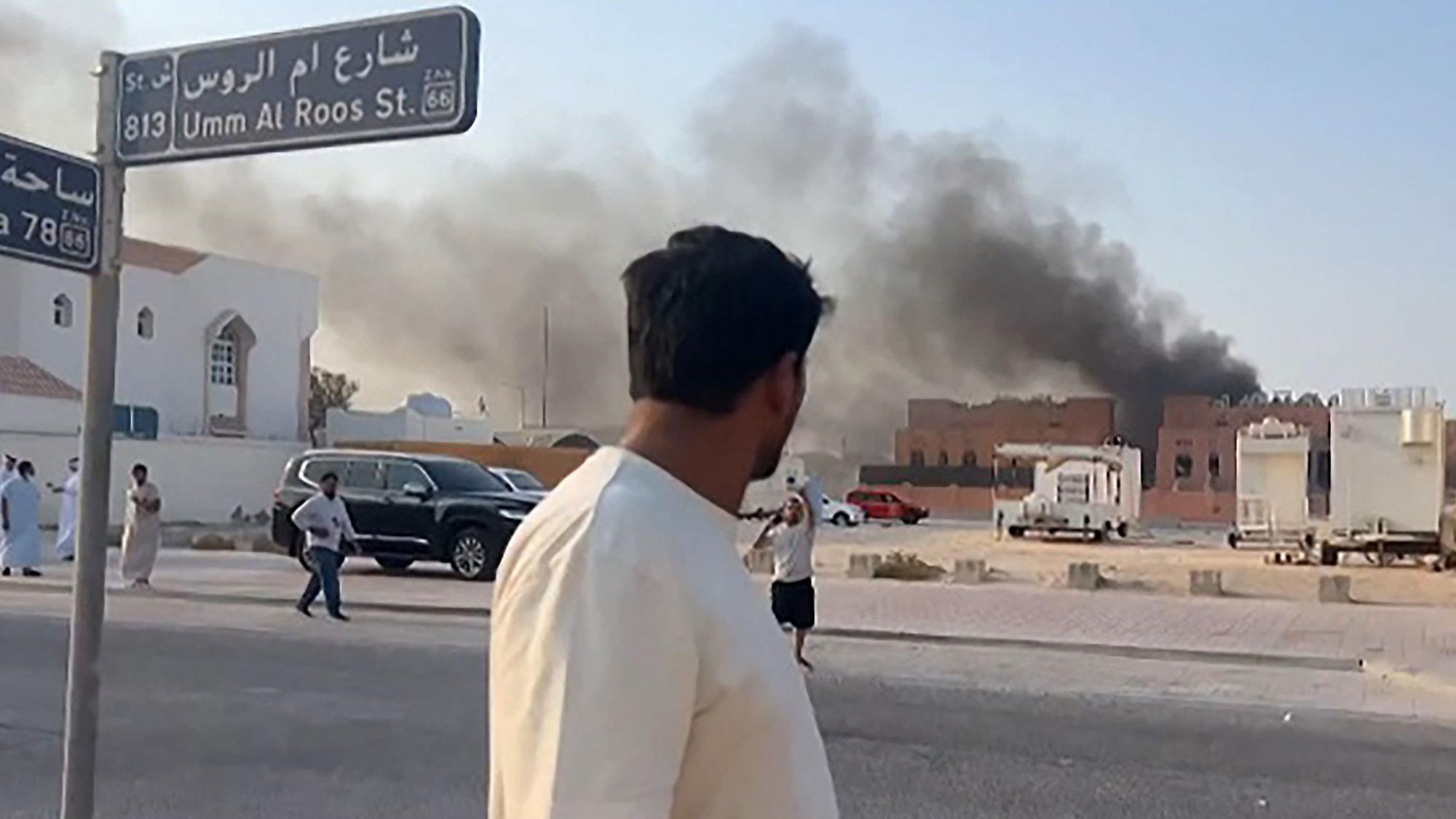Ein Standbild aus einem AFPTV-Video zeigt einen Mann, der nach Explosionen in der Hauptstadt Katars, Doha, aufsteigenden Rauch beobachtet.