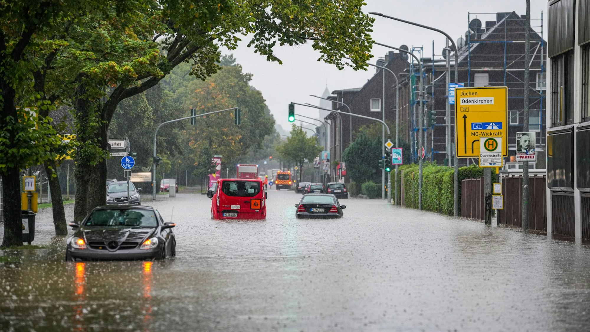 09.09.2025, Nordrhein-Westfalen, Mönchengladbach: Autos fahren bei starkem Regen durch eine überflut