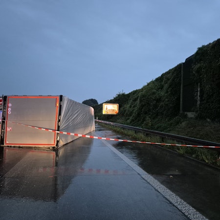 Ein LKW liegt auf der regennassen Fahrbahn. Wegen eines umgestürzten Lastwagens gibt es auf der Autobahn 4 kilometerlange Staus. Foto: Sascha Thelen/dpa+