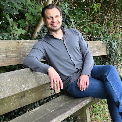 FDP-Landratskandidat Alexander Engel sitzt auf einer Bank.