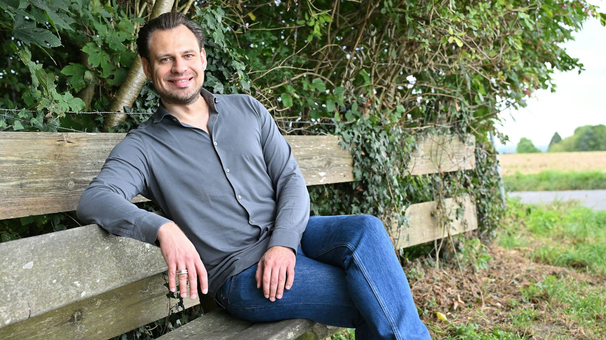 FDP-Landratskandidat Alexander Engel sitzt auf einer Bank.