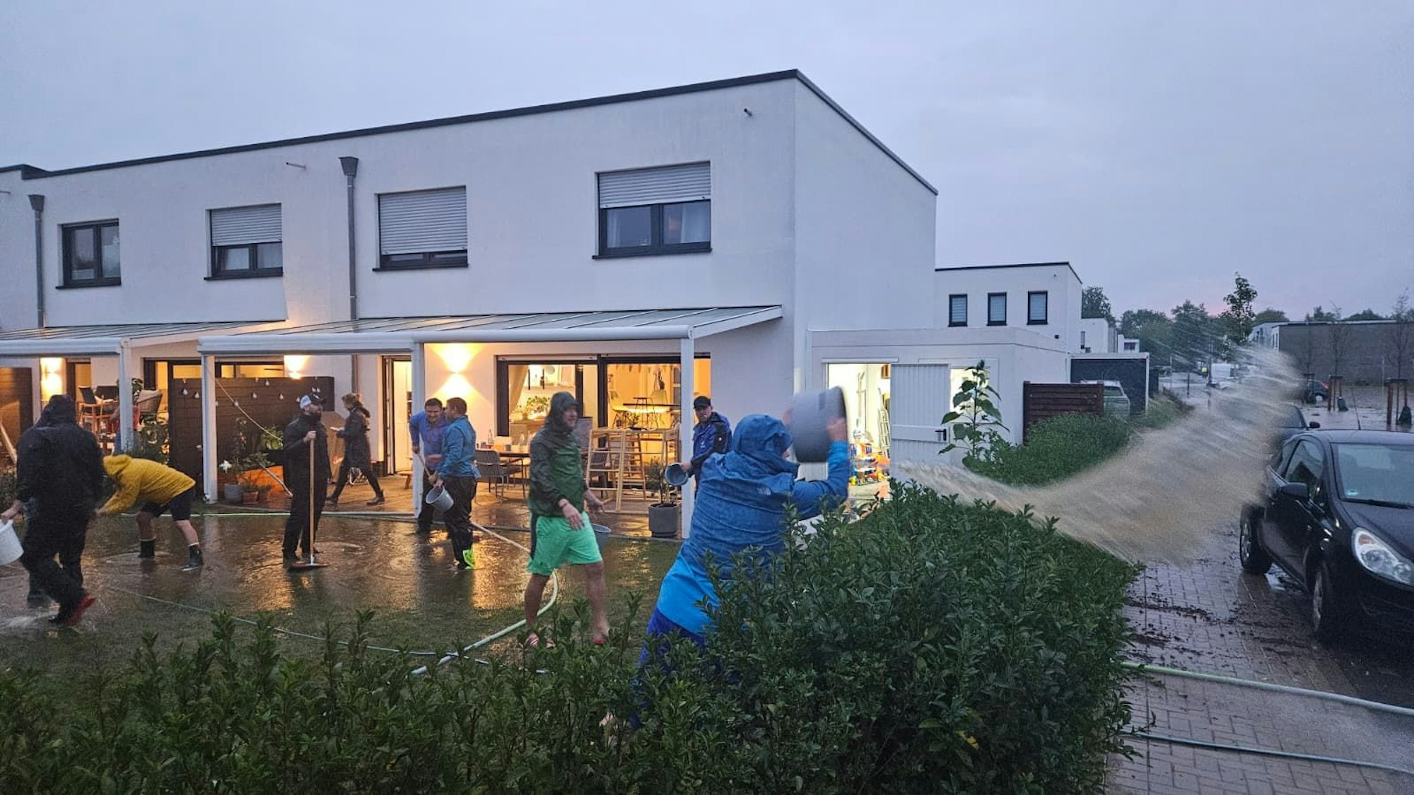 In der Ressourcenschutzsiedlung versuchen Anwohner mit vereinten Kräften, der Wassermassen Herr zu werden.