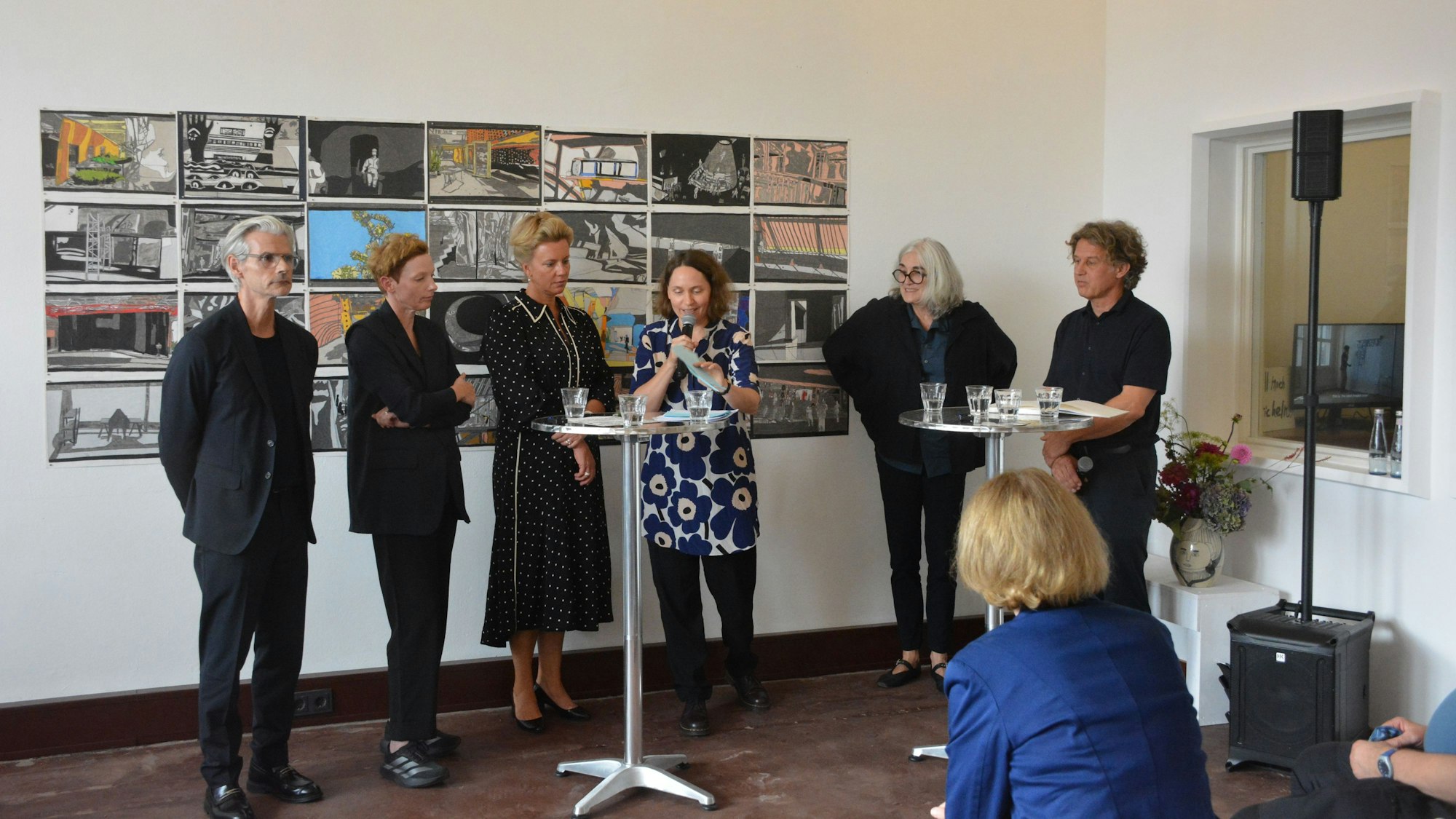 Eine Gruppe von Menschen hinter Stehtischen.