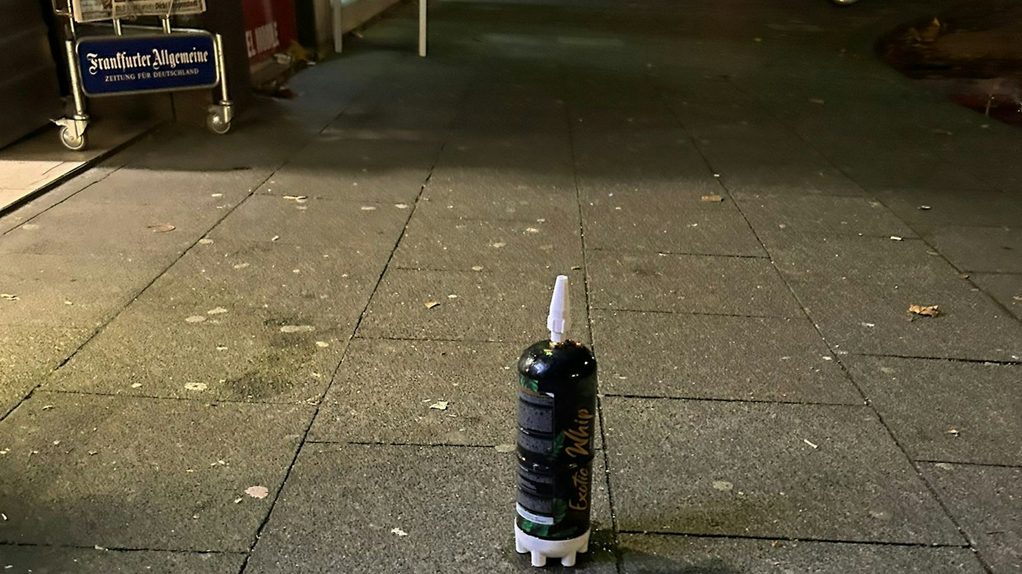 Eine Kartusche steht auf einem Bürgersteig.