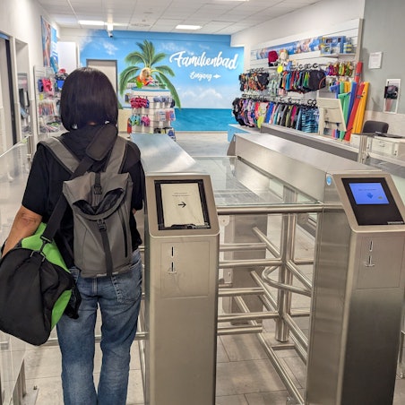 Das Foto zeigt eine Besucherin vor dem Drehkreuz am Eingang des Familienbads.