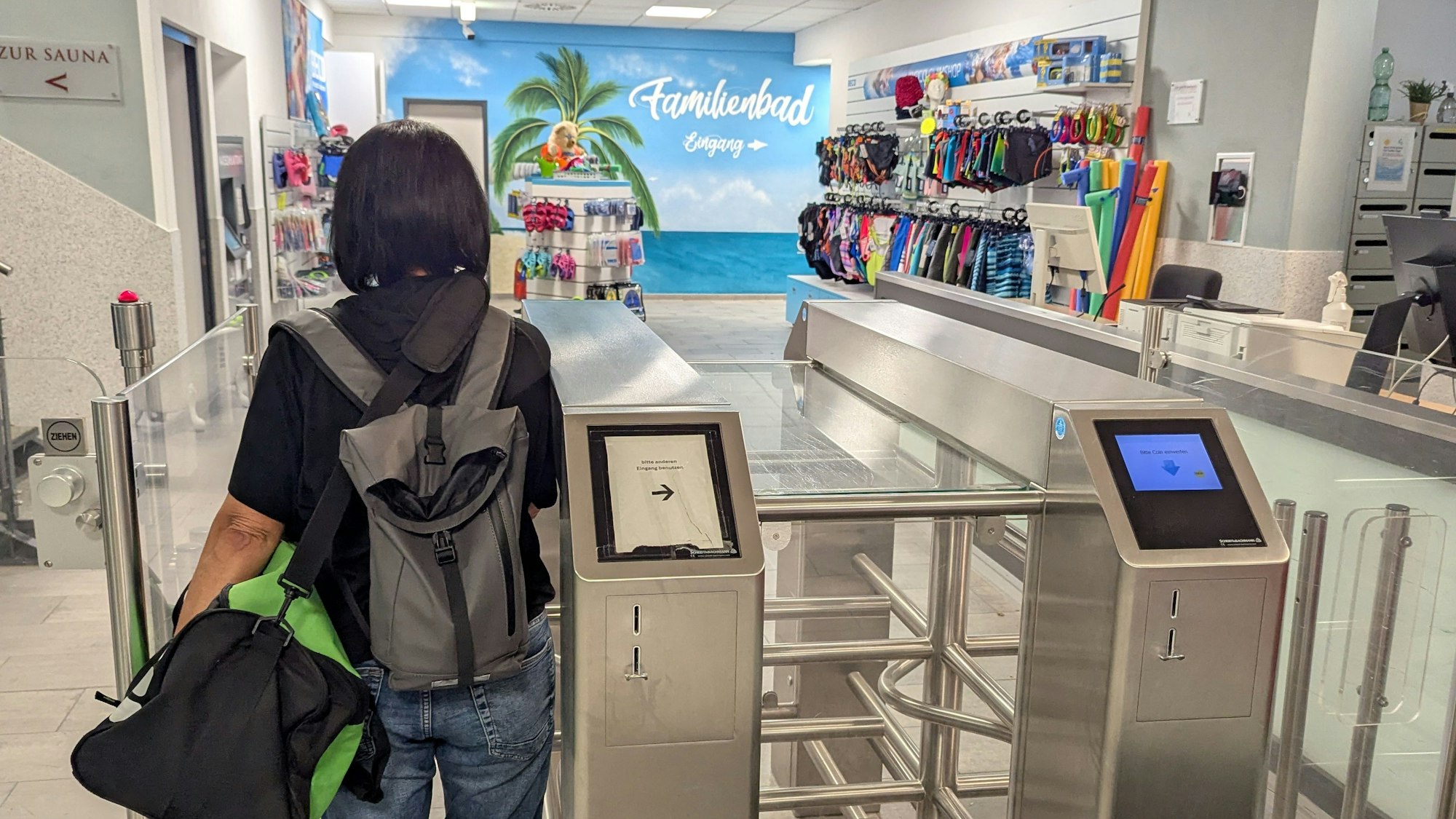 Das Foto zeigt eine Besucherin vor dem Drehkreuz am Eingang des Familienbads.
