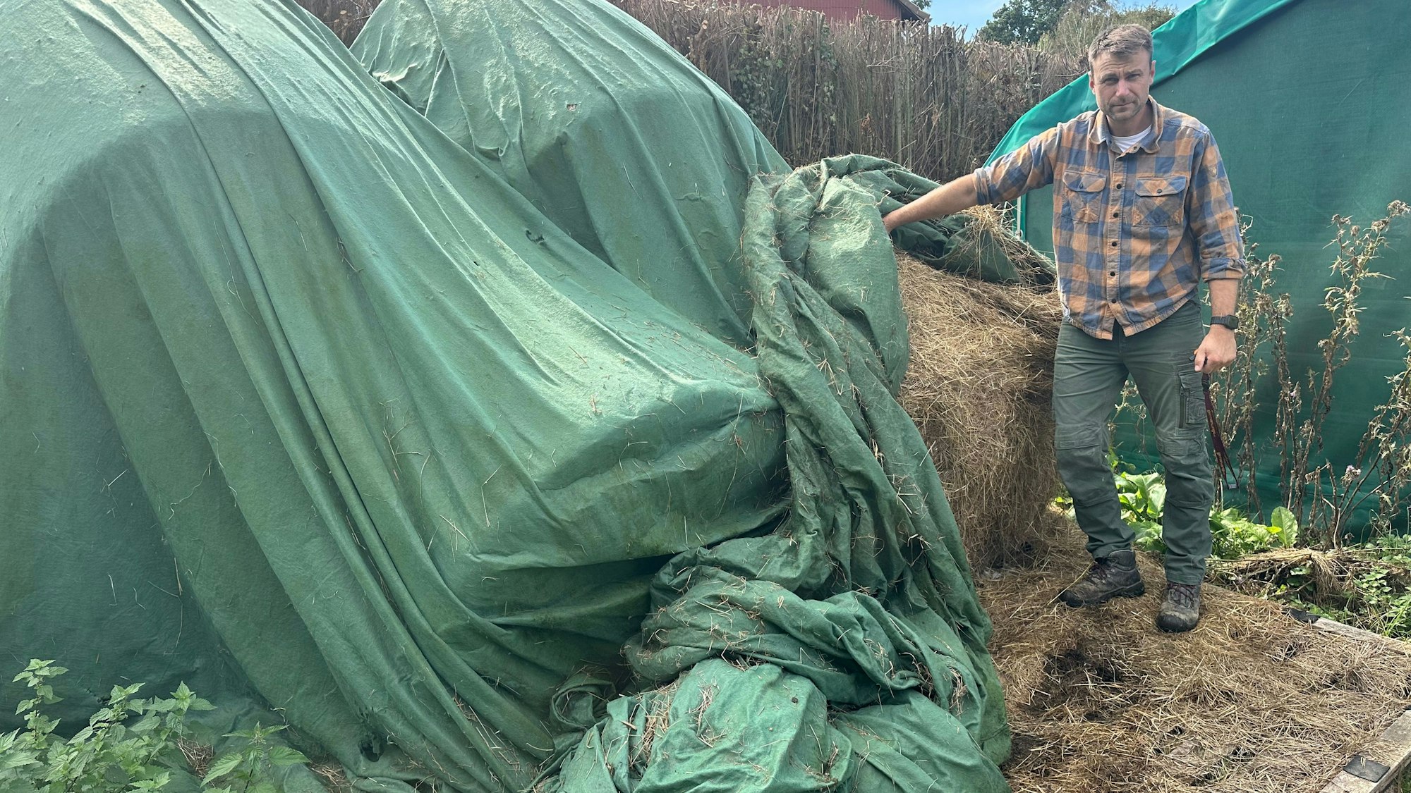 Mit einer Plane werden die Heuballen notdürftig geschützt. In einem Stall wären sie besser aufgehoben.