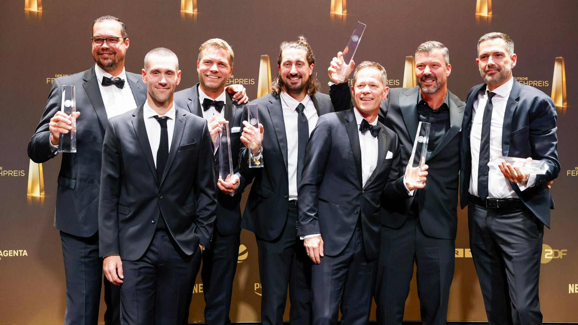 Das Team um Moderator Sascha Bandermann (3.v.r.) freut sich über die Auszeichnung in der Kategorie „Beste Sportsendung“ für die DEL-Übertragung auf MagentaTV.