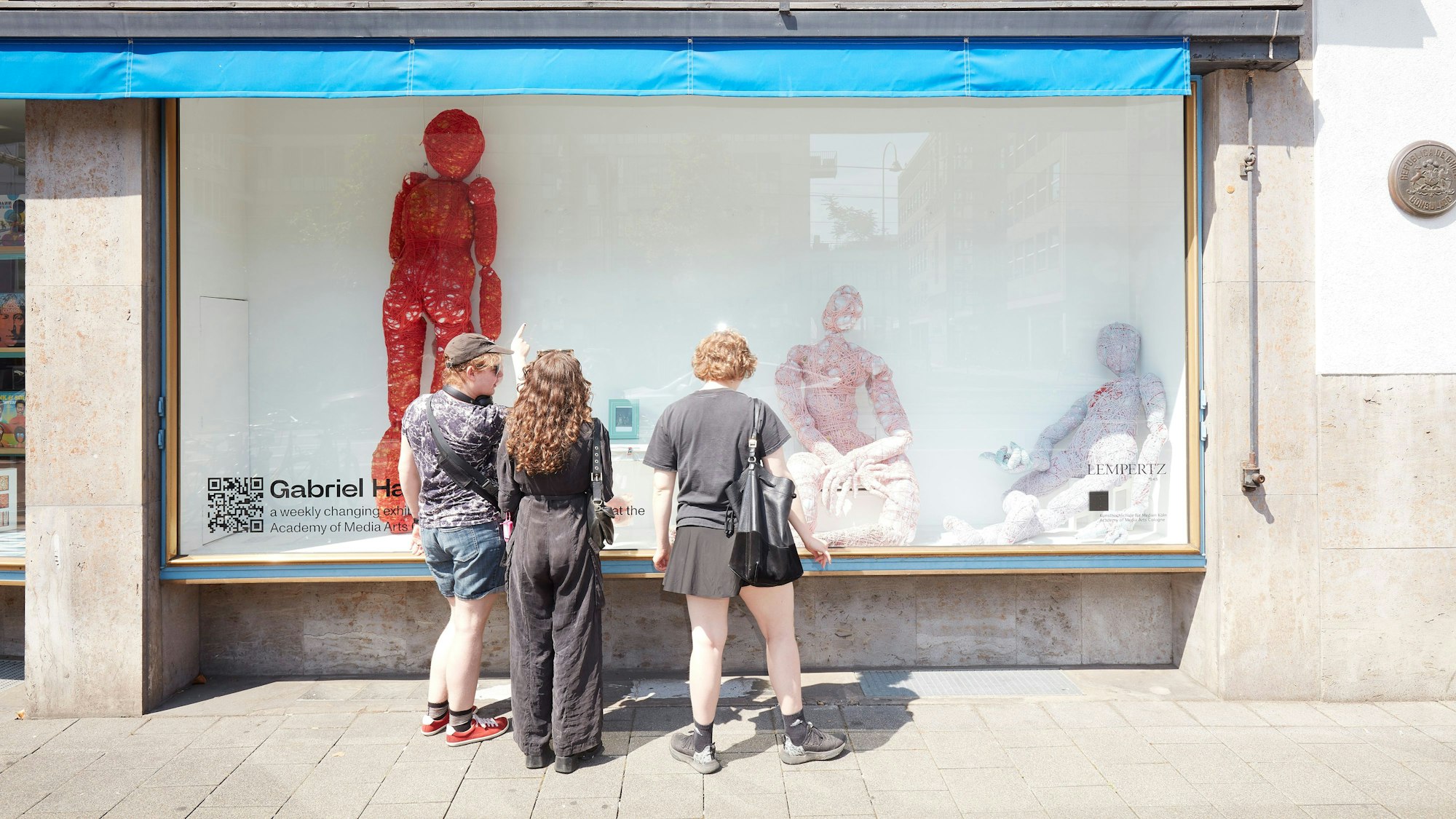 Drei Passantinnen betrachten die „Urban Stage“-Installation von Gabriel Hahner im Kölner Kunsthaus Lempertz.